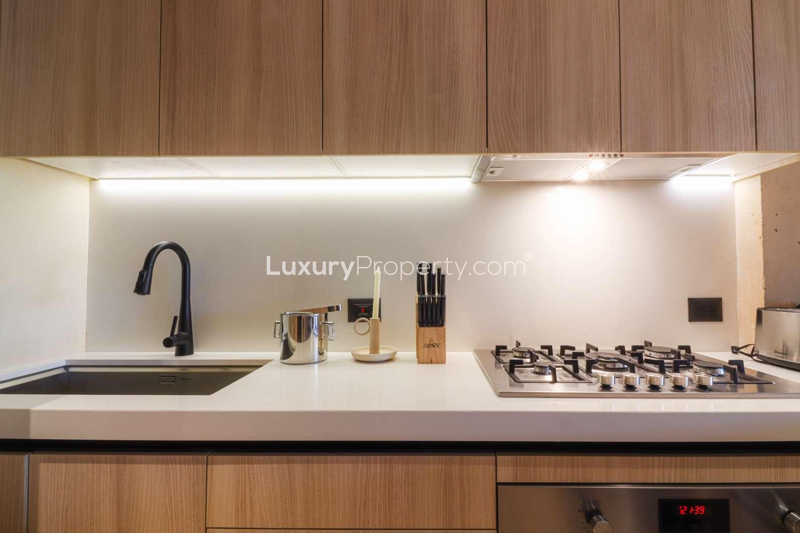 Modern kitchen in Garden Penthouse, The Village, Corasol Riviera Maya, with sleek wood cabinets