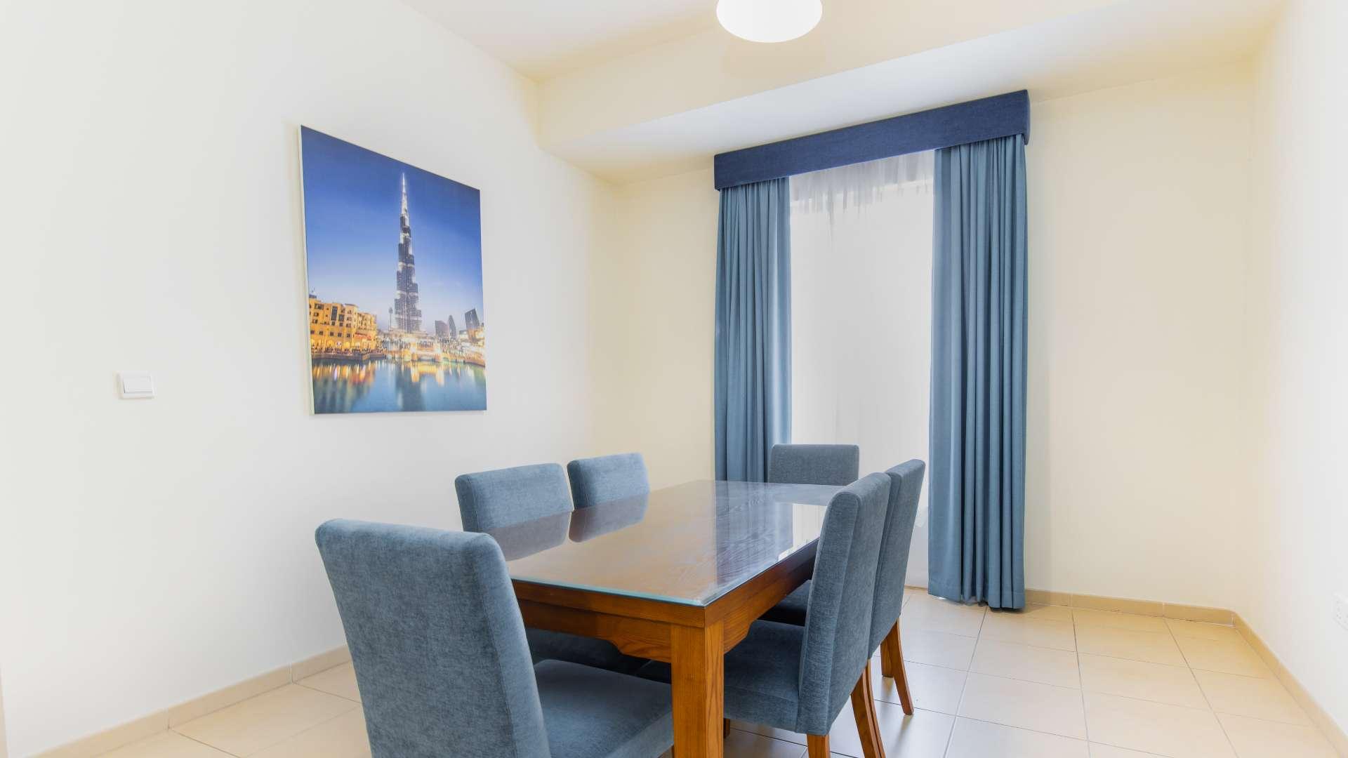 Modern kitchen in spacious JBR apartment, featuring sleek appliances and ample storage space