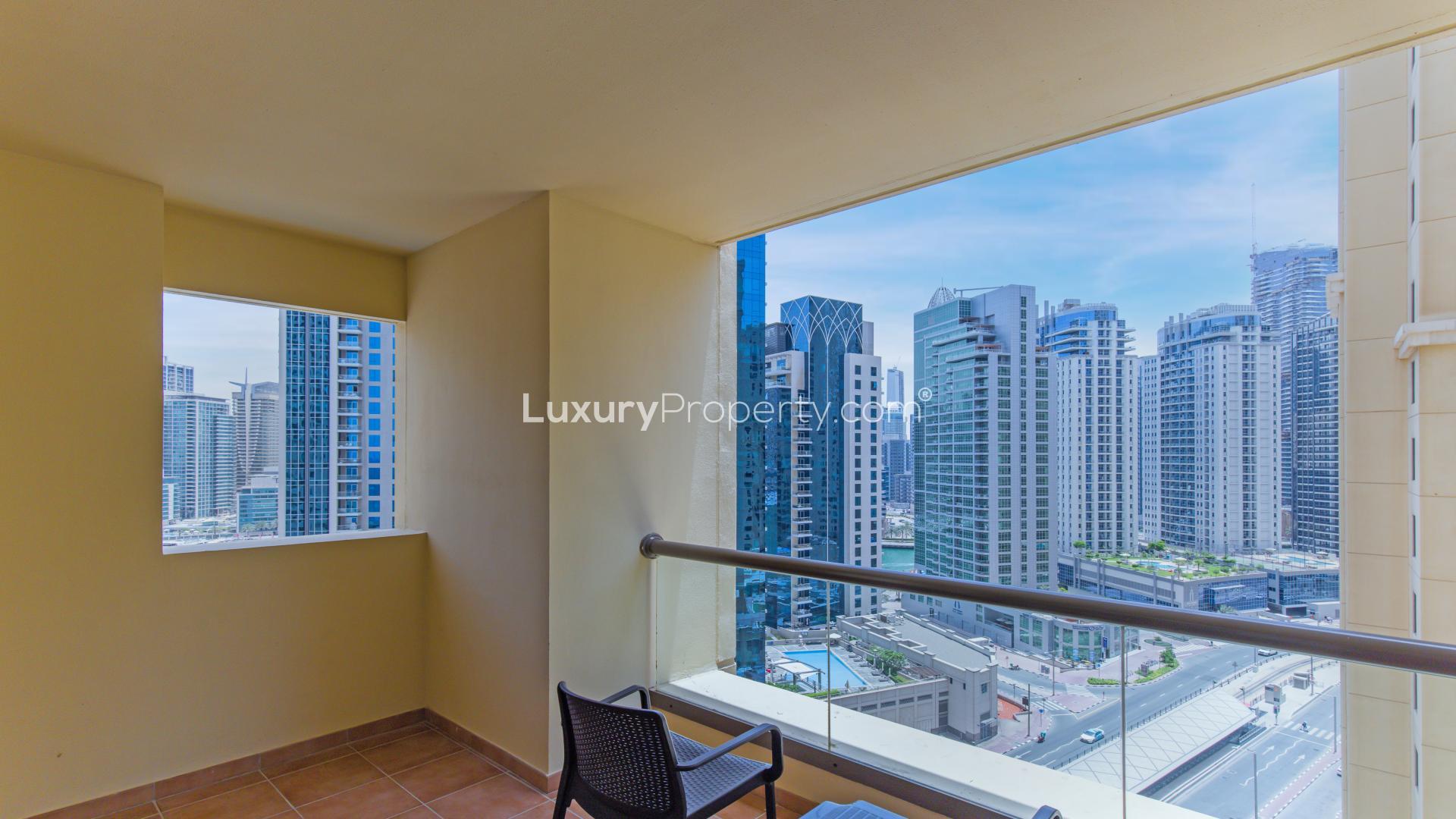 Dining area in furnished JBR apartment, Amwaj, with blue chairs and wall art