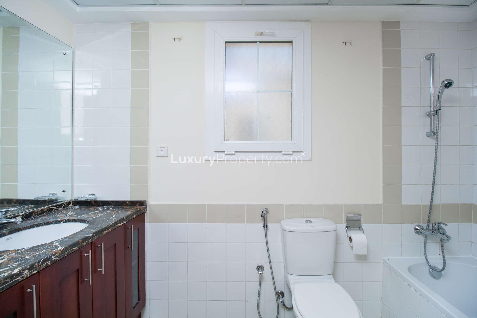 Empty living room in Arabian Ranches townhouse with tiled floor and pool view