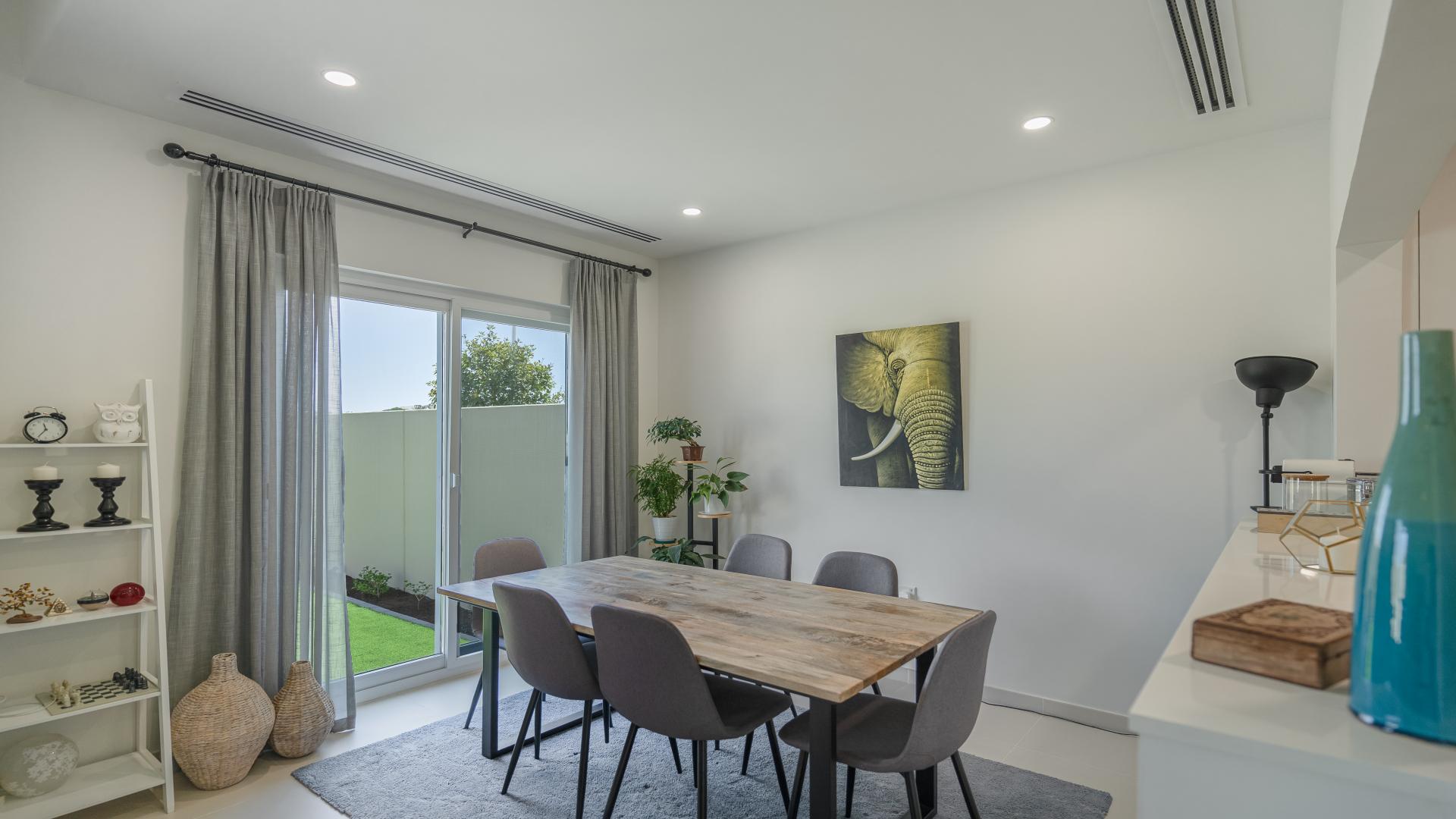 Exterior view of landscaped townhouse for rent in Villanova, Dubai Land, with garage