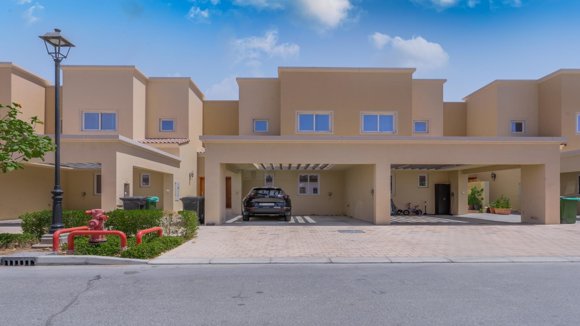 Luxurious living room in Villanova townhouse, Dubai Land, with modern decor and garden view