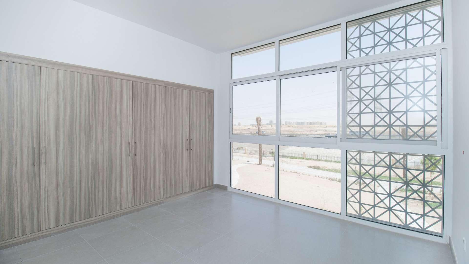 Outdoor pool area with sun loungers in Arabella Townhouses, Mudon community