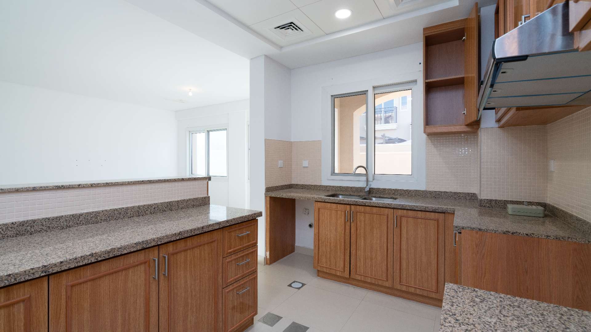 Modern kitchen with wooden cabinets in Bella Casa townhouse, Serena, Dubai for rent