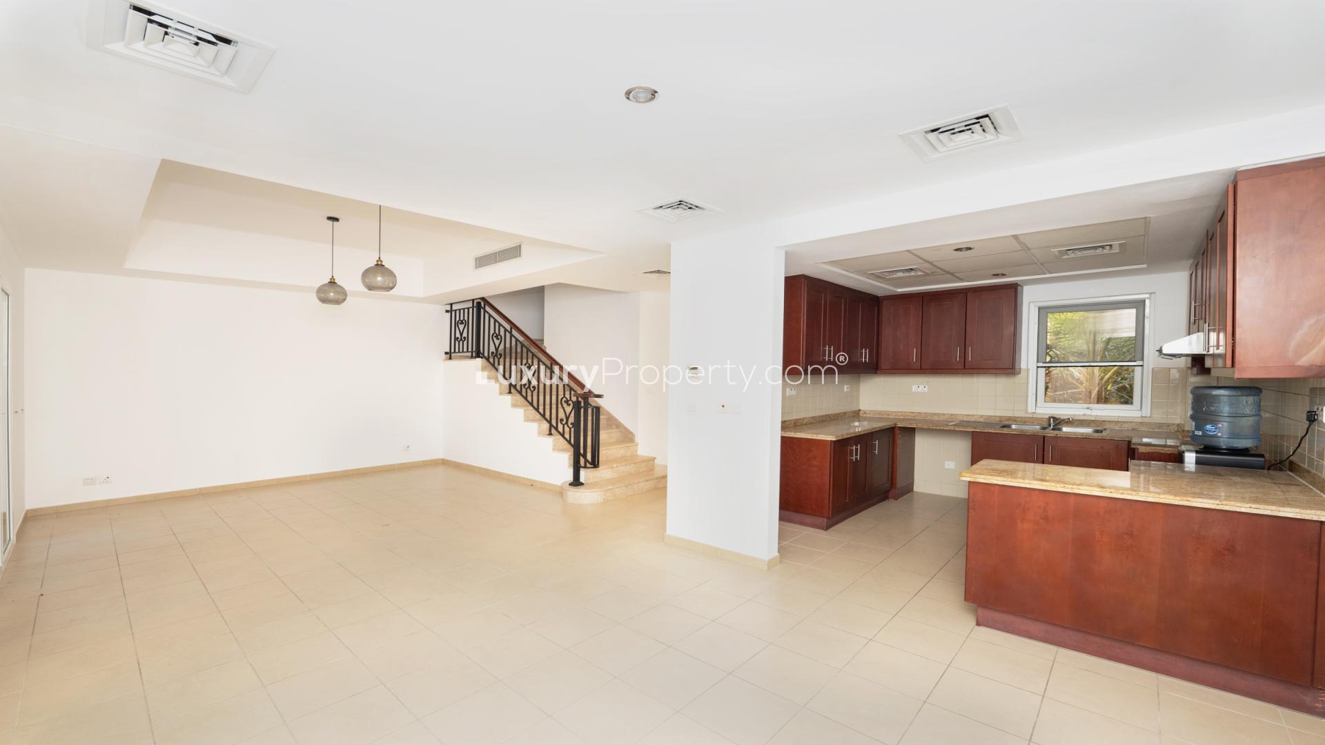 "View from villa balcony overlooking lush garden in Palmera, Arabian Ranches, available for rent.",Interior view of Arabian Ranches villa kitchen and living area, Palmera community