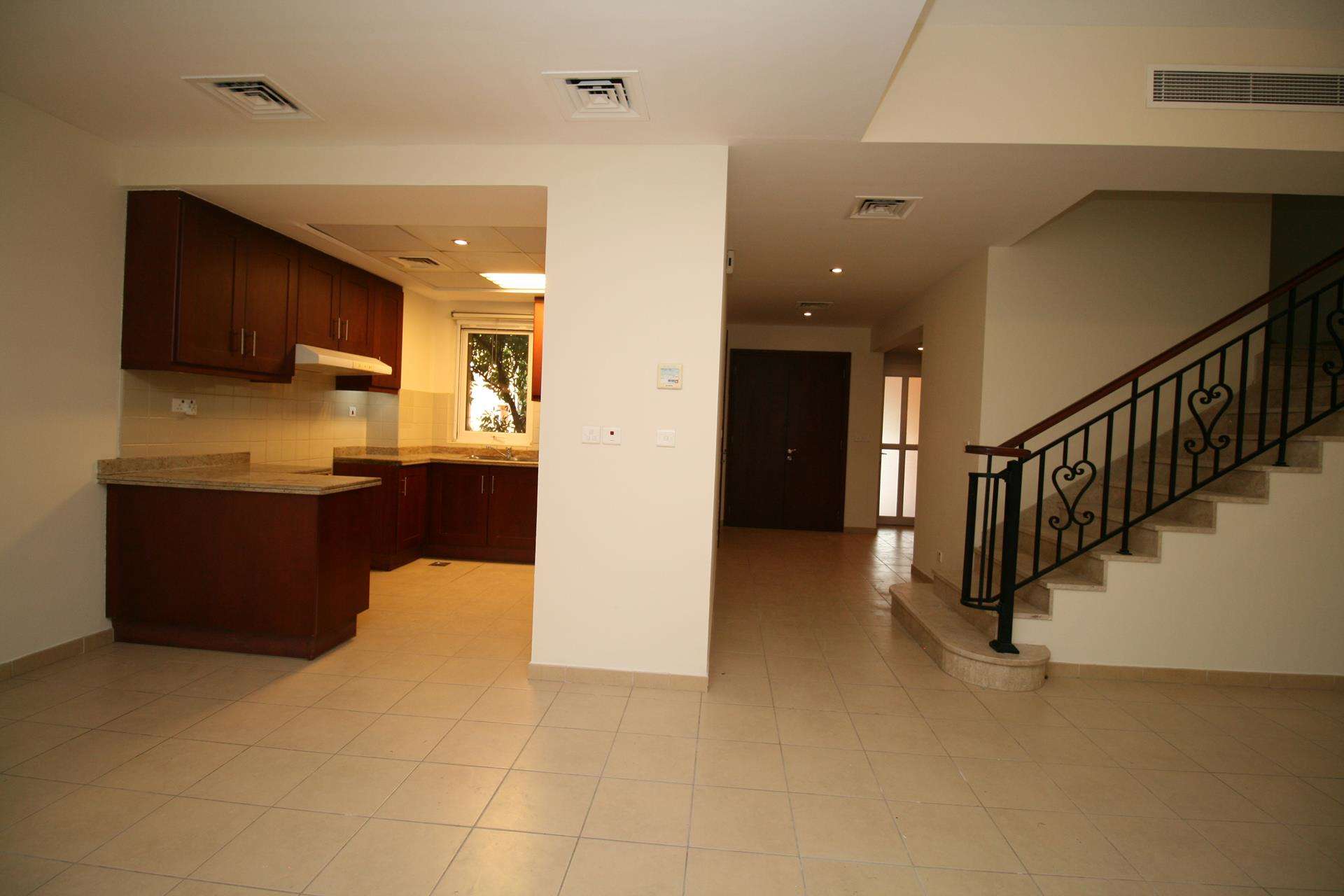 Spacious living area in Palmera 2-bedroom villa, Arabian Ranches, with open kitchen and staircase
