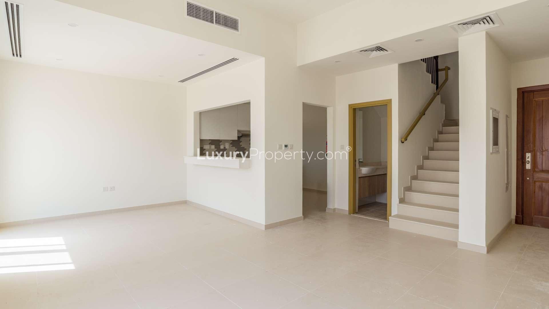 Modern open-plan townhouse interior in Villanova, Dubai Land with staircase and breakfast bar