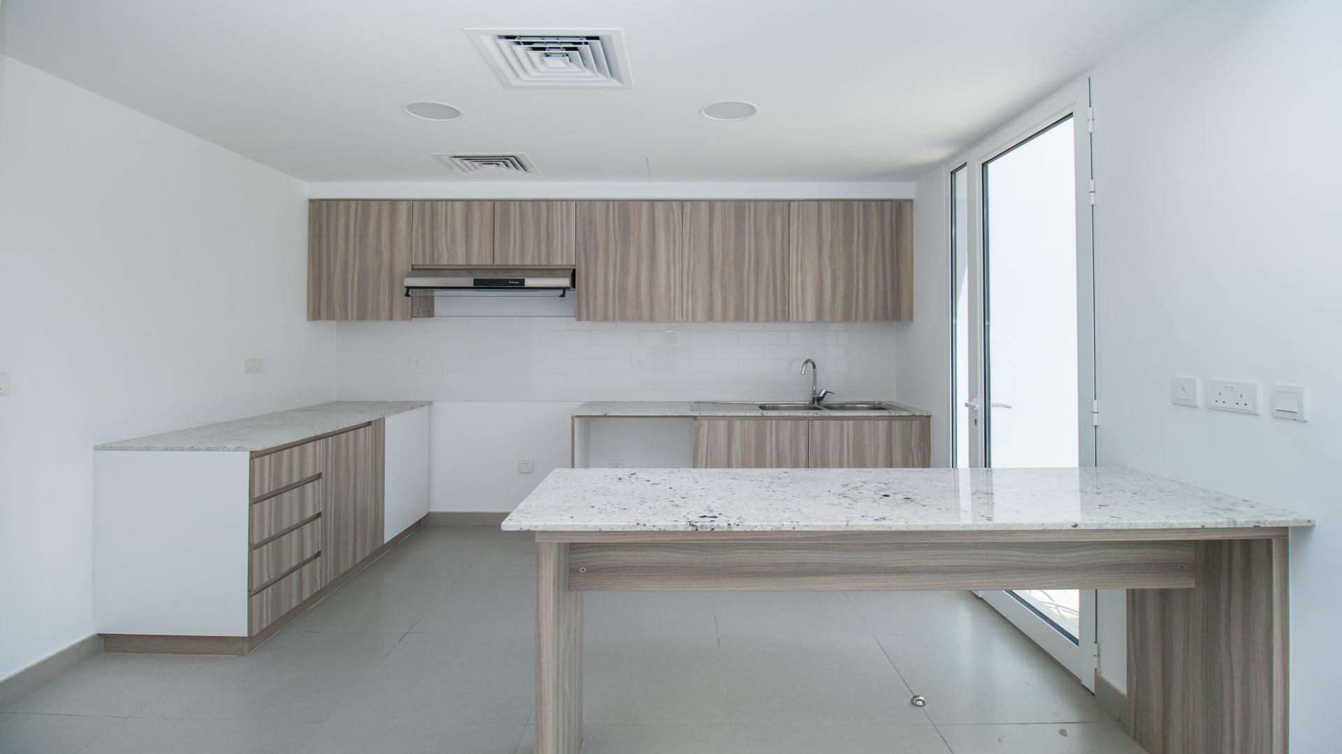 Bright living room with large windows in Mudon Arabella townhouse for sale