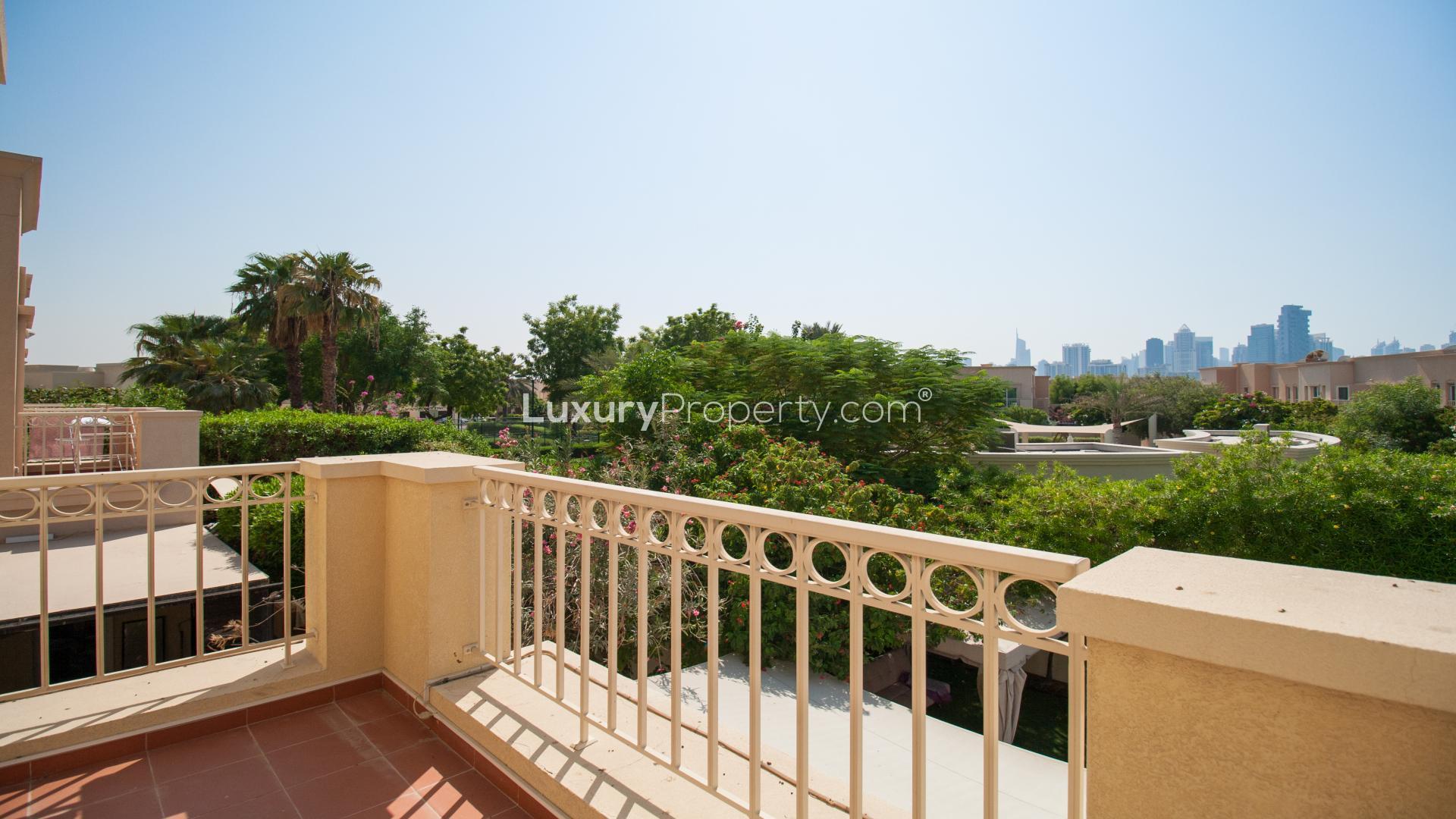 Balcony view of Maeen villa overlooking lush greenery and skyline in The Lakes community