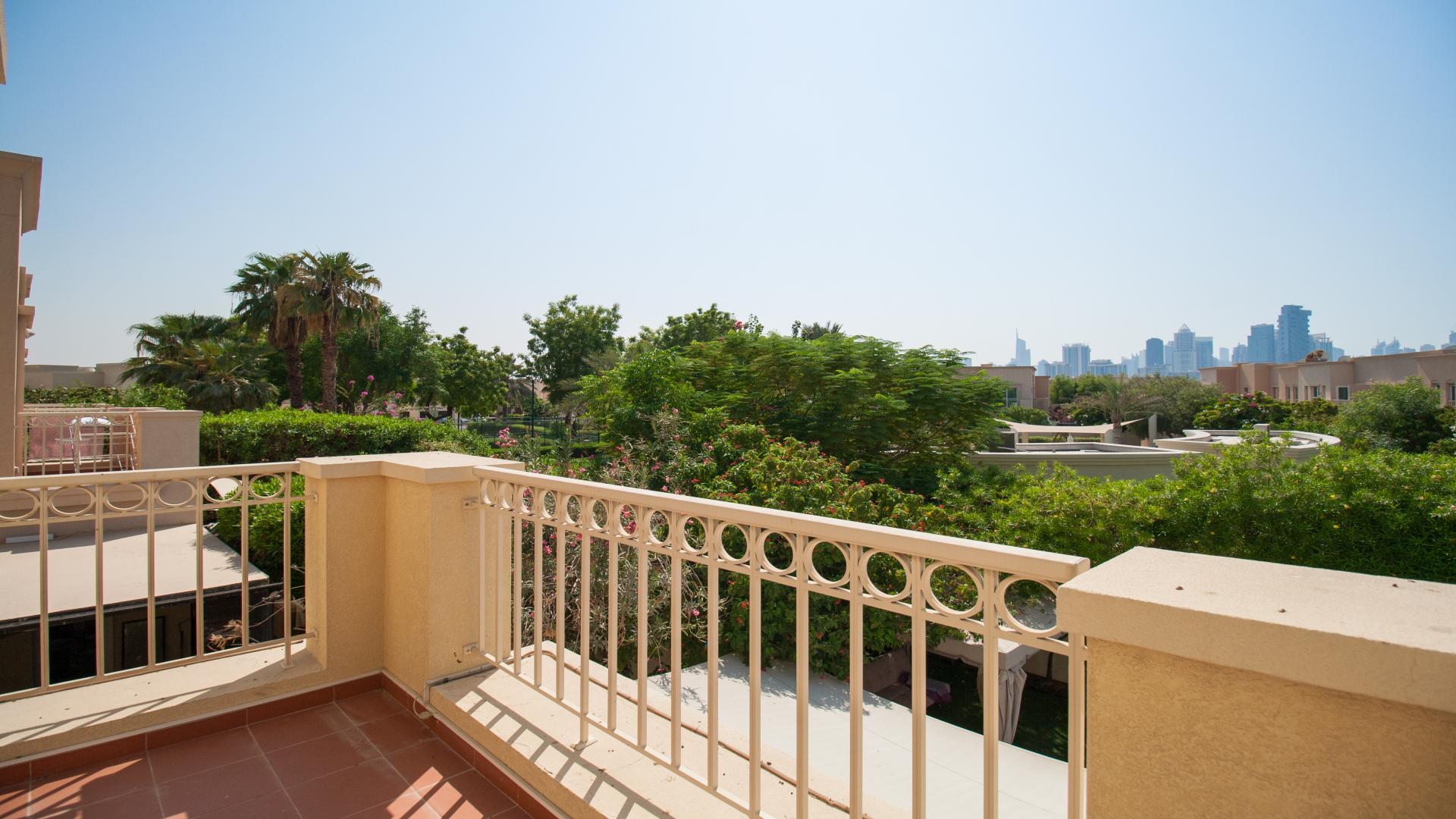 Balcony view of Maeen villa overlooking lush greenery and skyline in The Lakes community