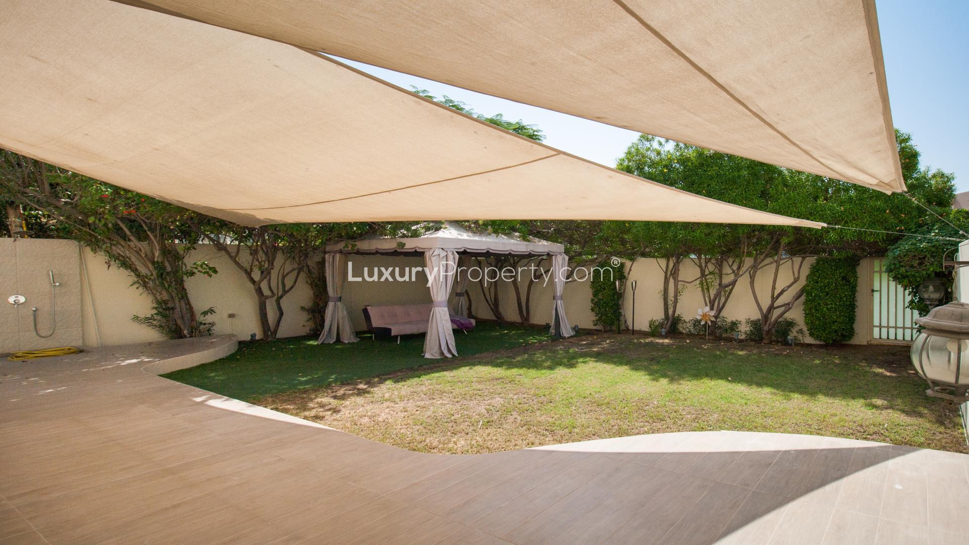 Exterior view of villa with patio and garden in Maeen, The Lakes community