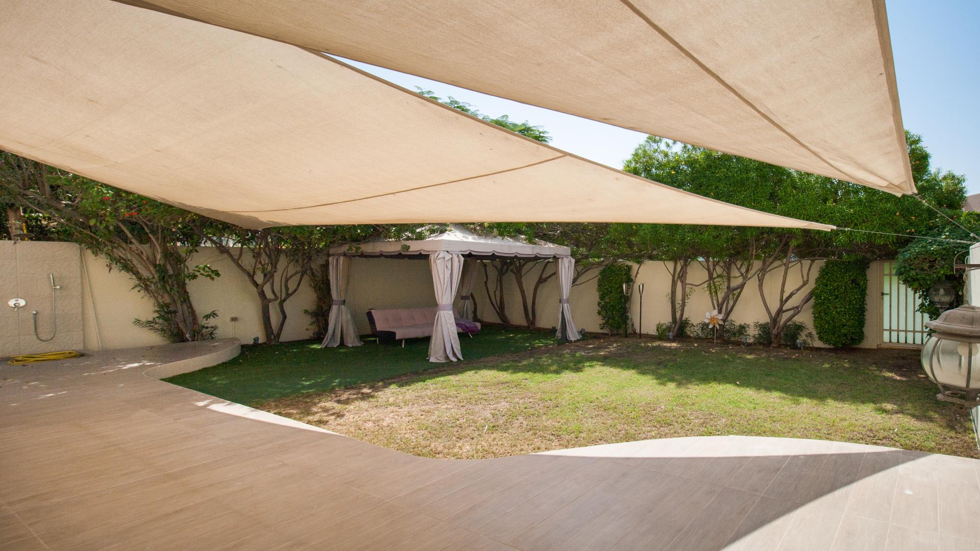 Exterior view of villa with patio and garden in Maeen, The Lakes community