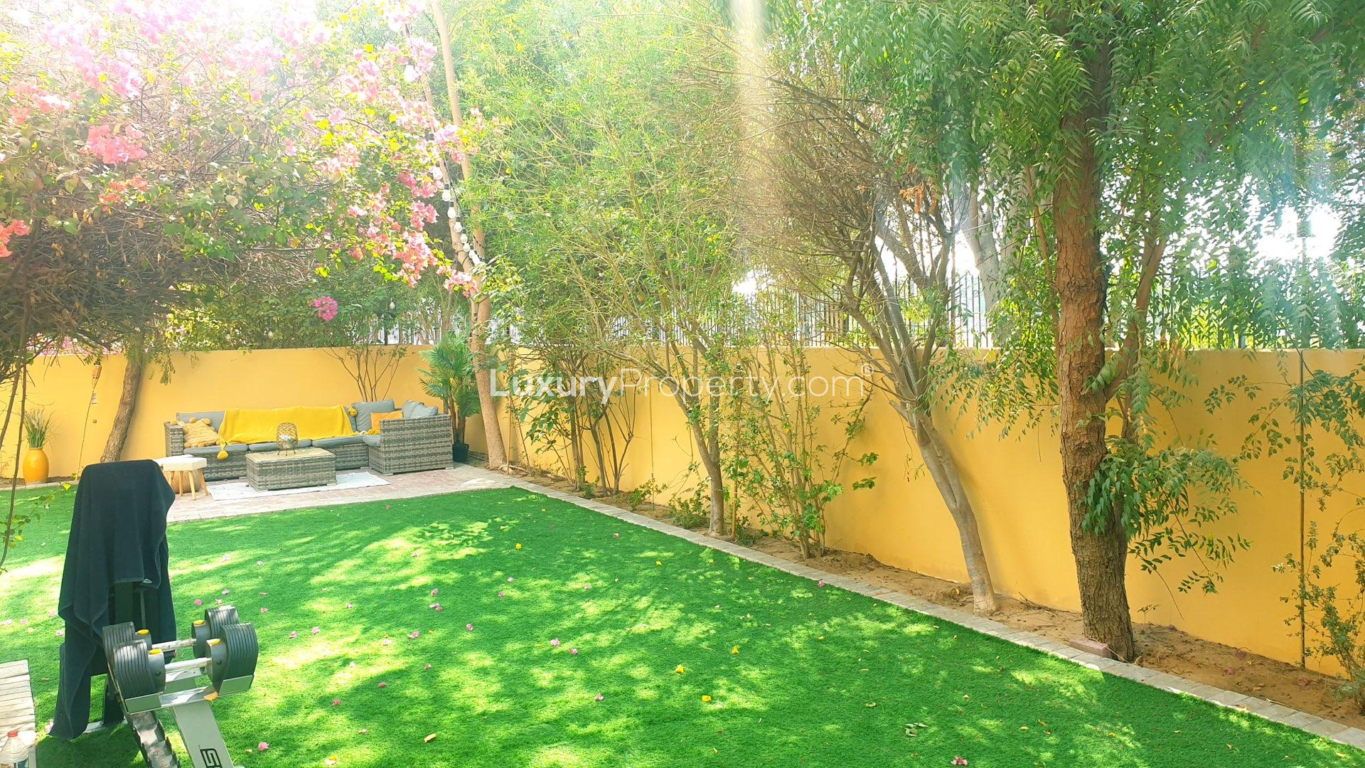 Two-bedroom villa garden with lush greenery and barbecue area in Palmera, Arabian Ranches