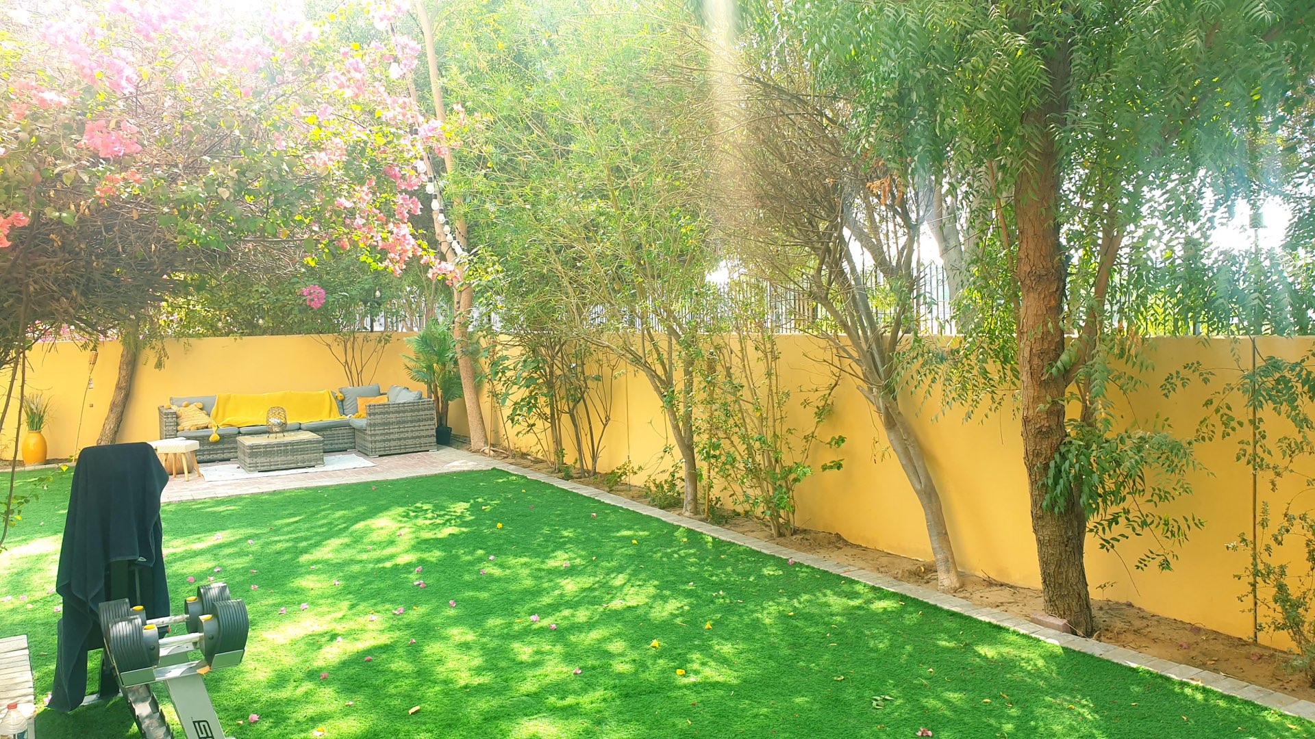 Two-bedroom villa garden with lush greenery and barbecue area in Palmera, Arabian Ranches