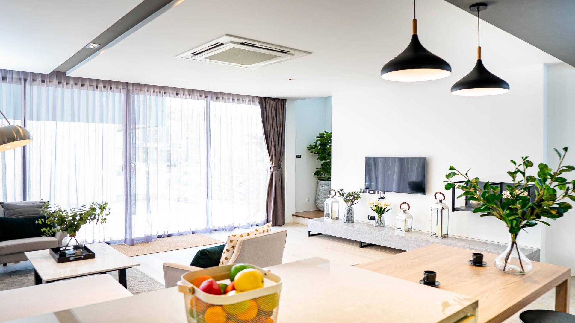 Modern living area in beachfront townhouse, Phuket. Stylish decor, open kitchen, cozy seating