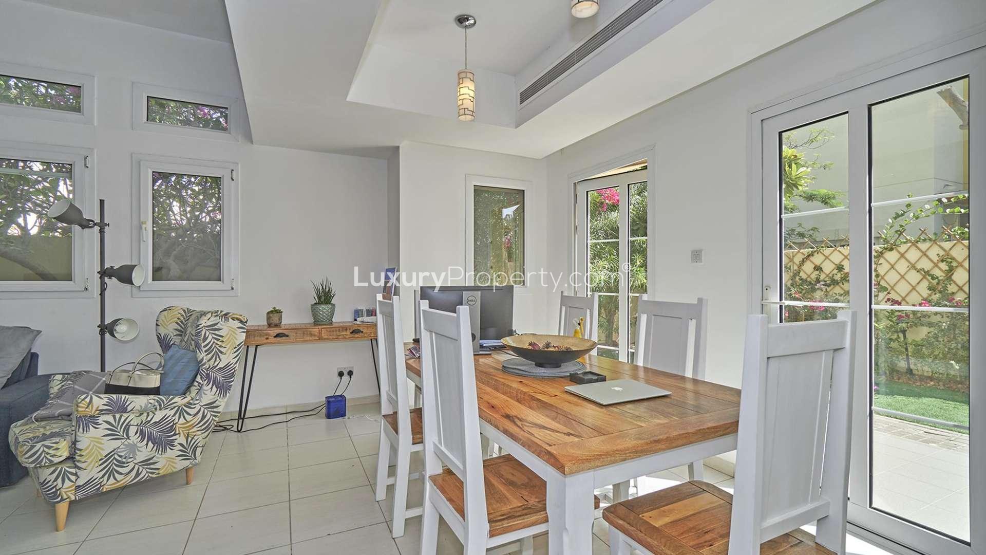 Alt text: "Spacious garden view from upgraded two-bedroom villa in Maeen, The Lakes community.","Bright dining area in upgraded two-bedroom villa, Maeen, The Lakes, for rent.",Cozy living room in fully upgraded two-bedroom villa, Maeen, The Lakes