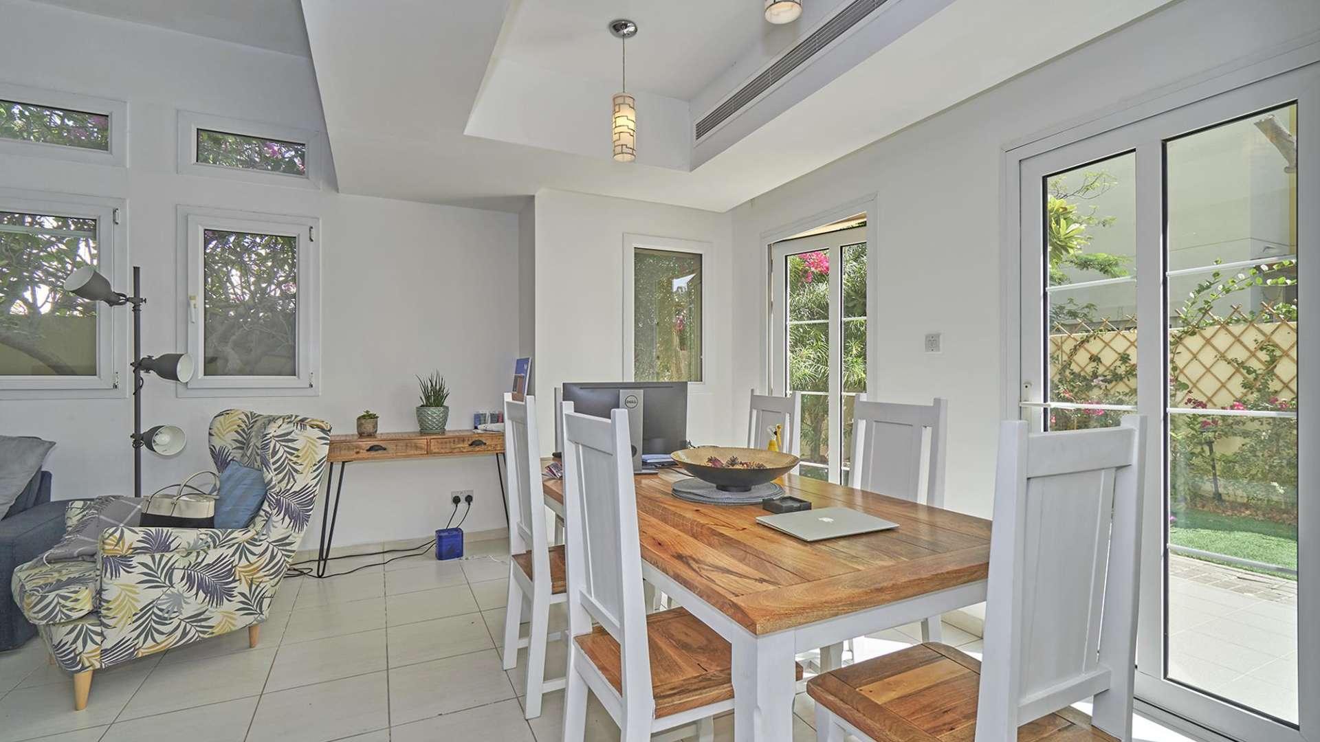 Alt text: "Spacious garden view from upgraded two-bedroom villa in Maeen, The Lakes community.","Bright dining area in upgraded two-bedroom villa, Maeen, The Lakes, for rent.",Cozy living room in fully upgraded two-bedroom villa, Maeen, The Lakes