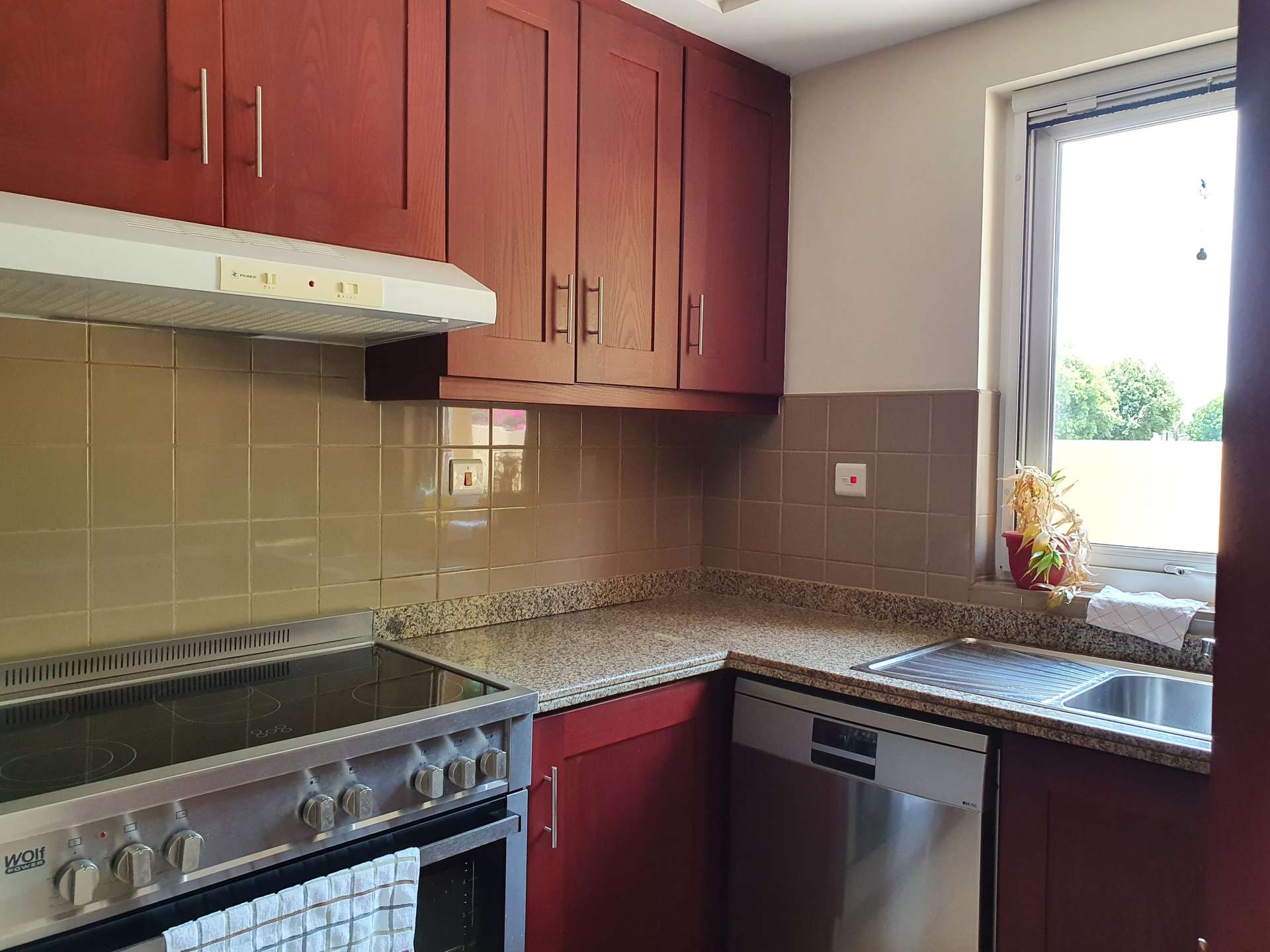 Modern kitchen in 2-bedroom villa, Palmera 2, Arabian Ranches, with red cabinets and appliances
