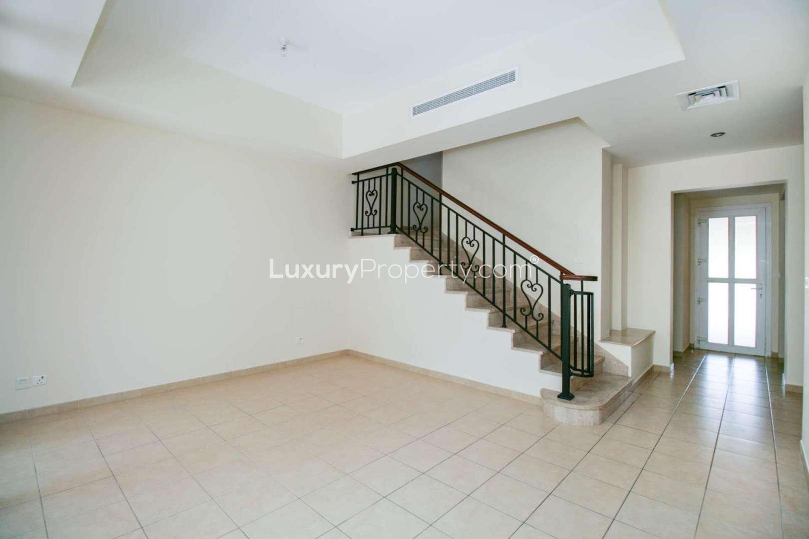 Empty living room with tiled floor and large window in Arabian Ranches villa for rent