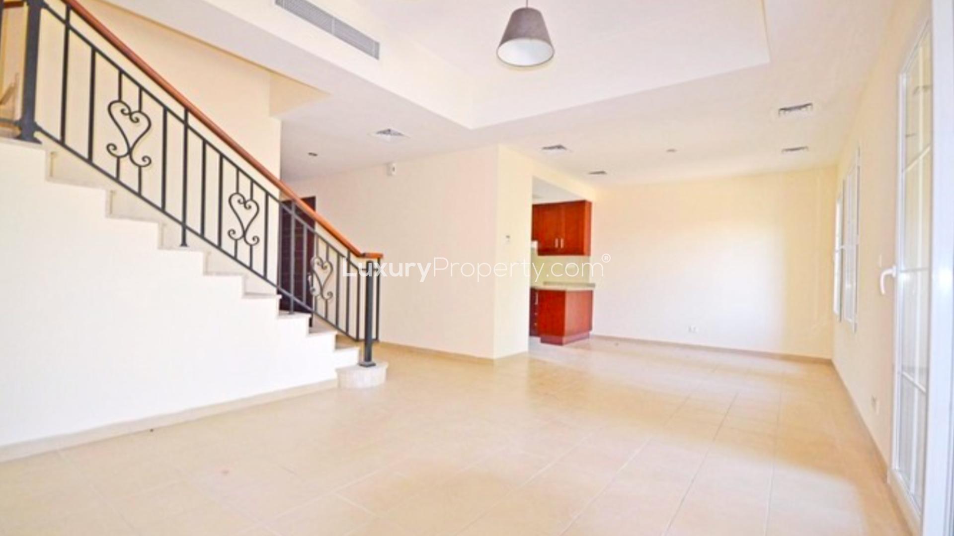 Vacant townhouse with lake view in Palmera, Arabian Ranches, lush greenery and pool visible