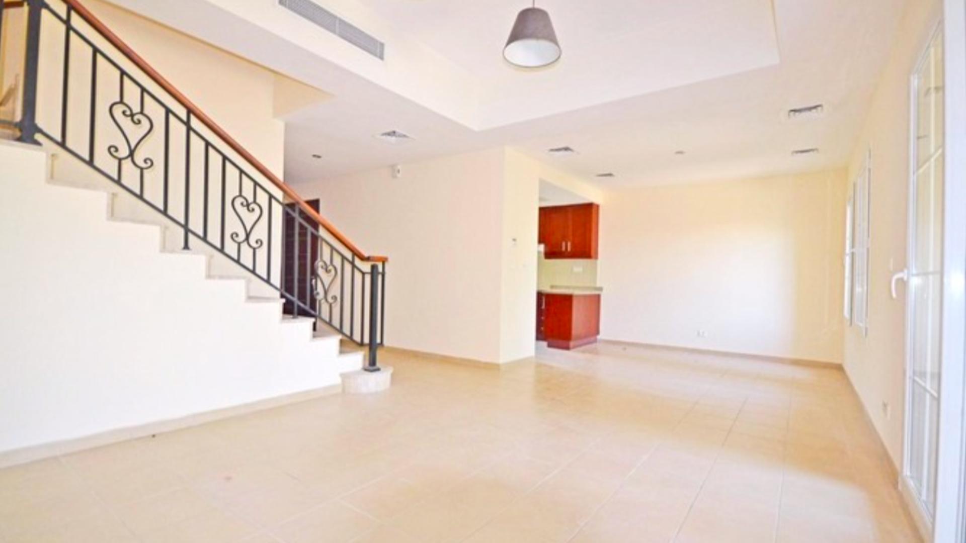 Vacant townhouse with lake view in Palmera, Arabian Ranches, lush greenery and pool visible