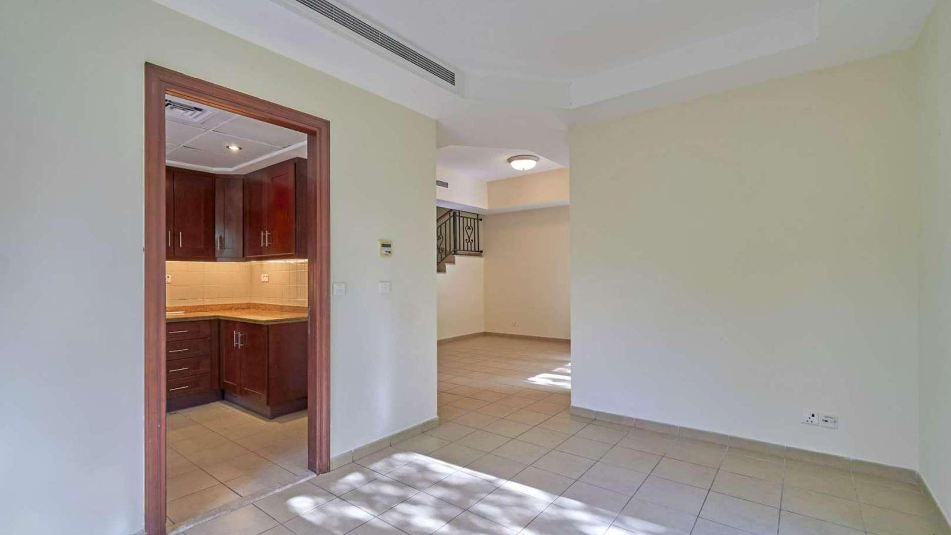 Bright living area in Palmera 1 villa, Arabian Ranches, with garden view through glass doors