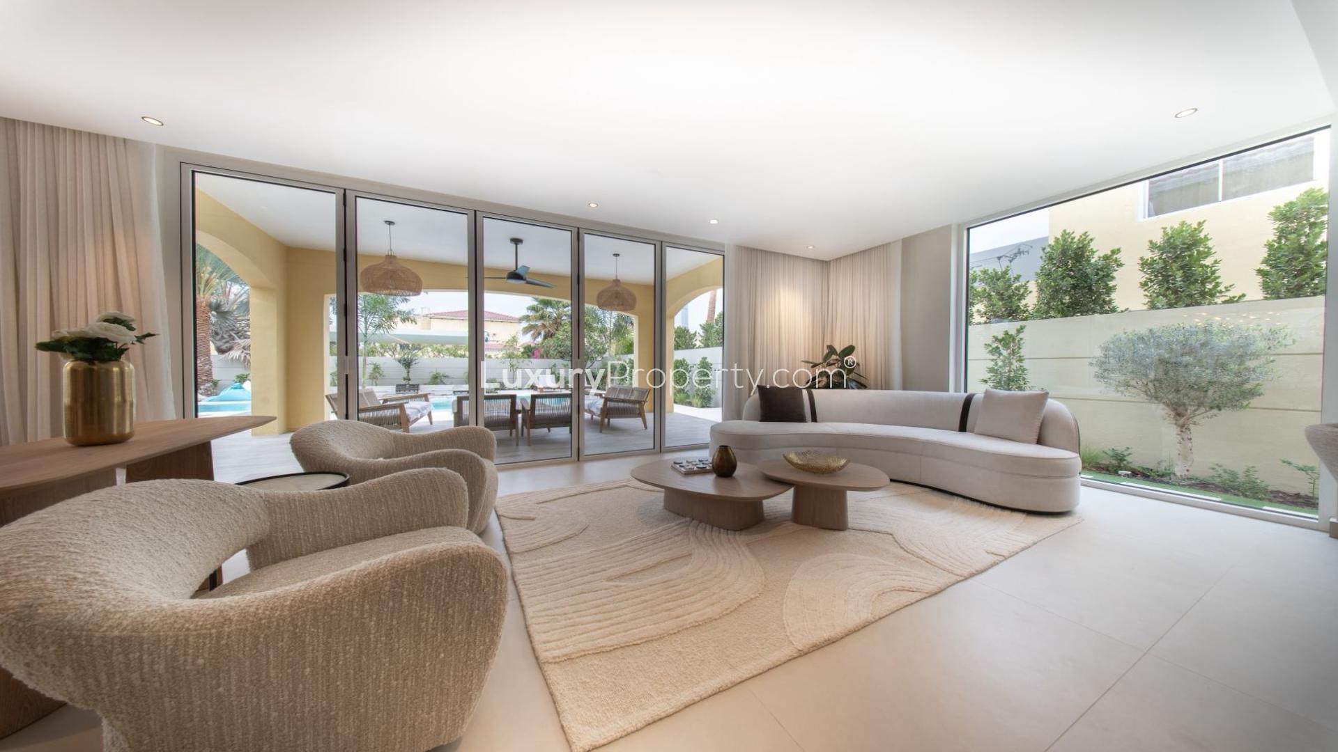 Modern living room in Jumeirah Park Villa with garden view, elegant furnishings, and natural light
