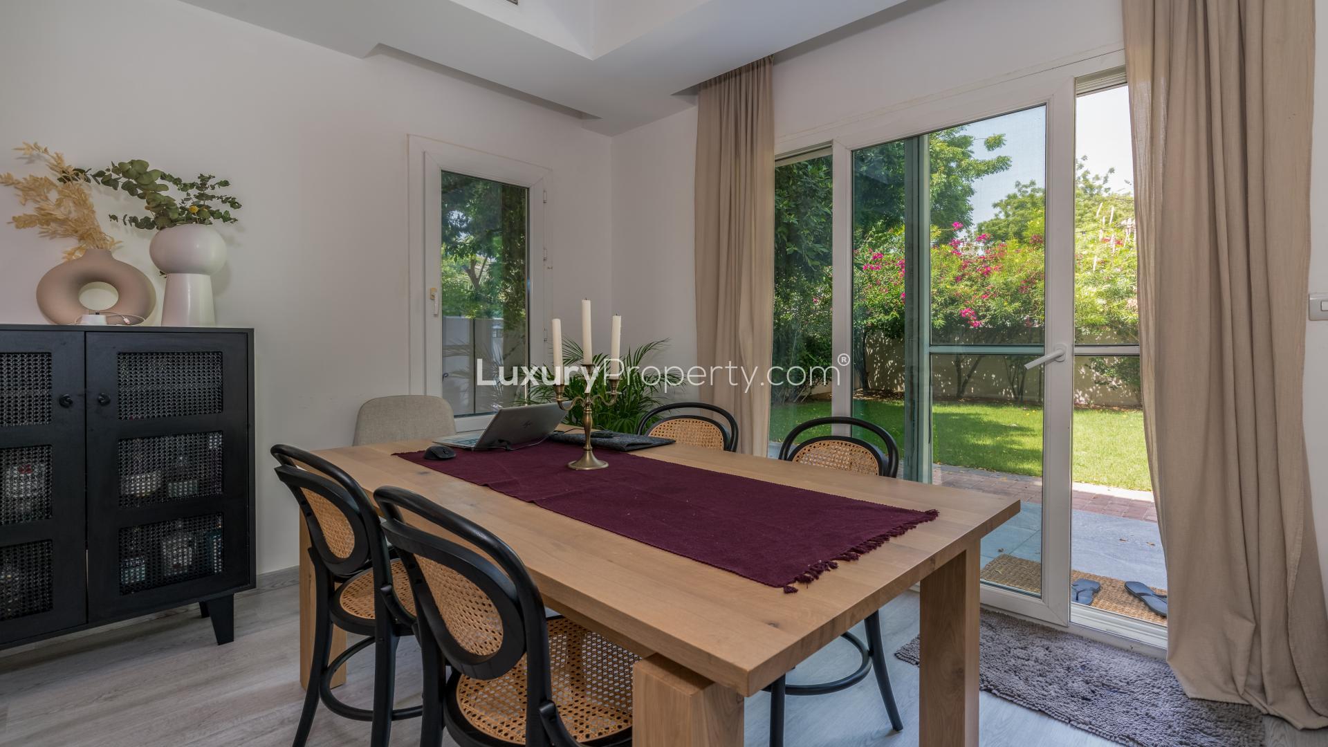 Modern living room in Maeen villa, The Lakes, with stylish decor and garden view