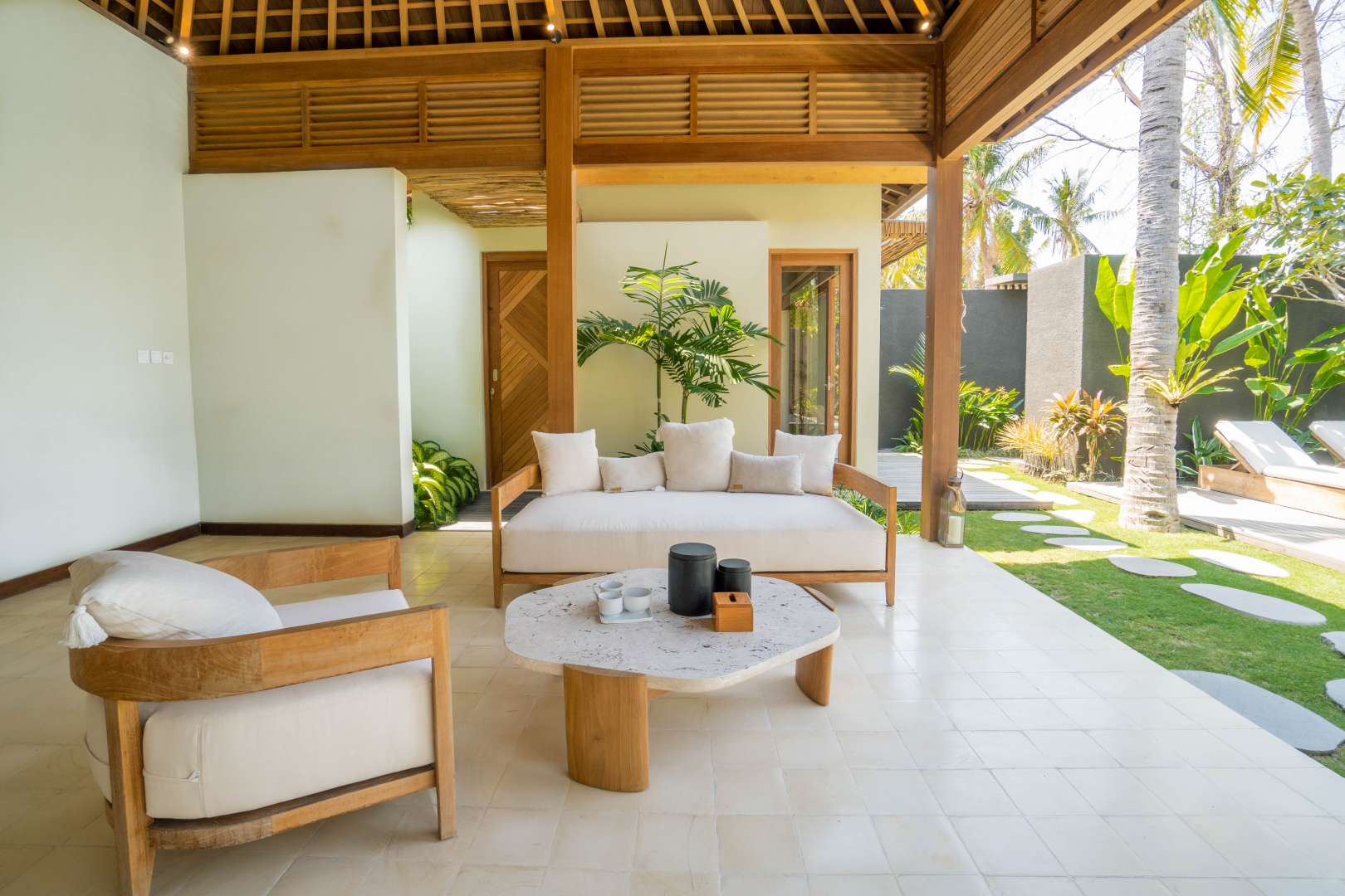 Outdoor lounge area at stylish two-bedroom villa, Cocana Resort, Lombok, with lush greenery