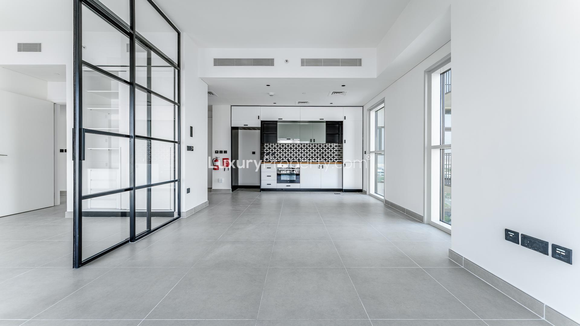 "Dubai Hills Estate aerial view showcasing modern apartments and vibrant community landscape.",Modern, vacant 2-bed apartment interior with glass doors in Dubai Hills Estate, Collective