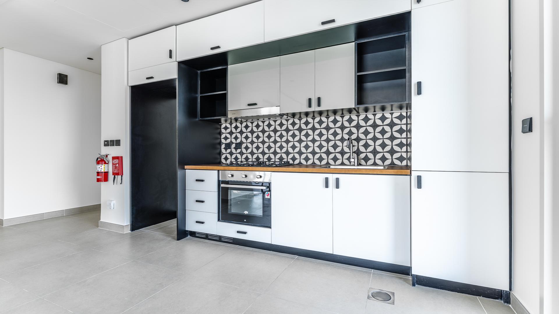 Modern kitchen in vacant 2-bed apartment, Dubai Hills Estate, with stylish cabinetry and backsplash