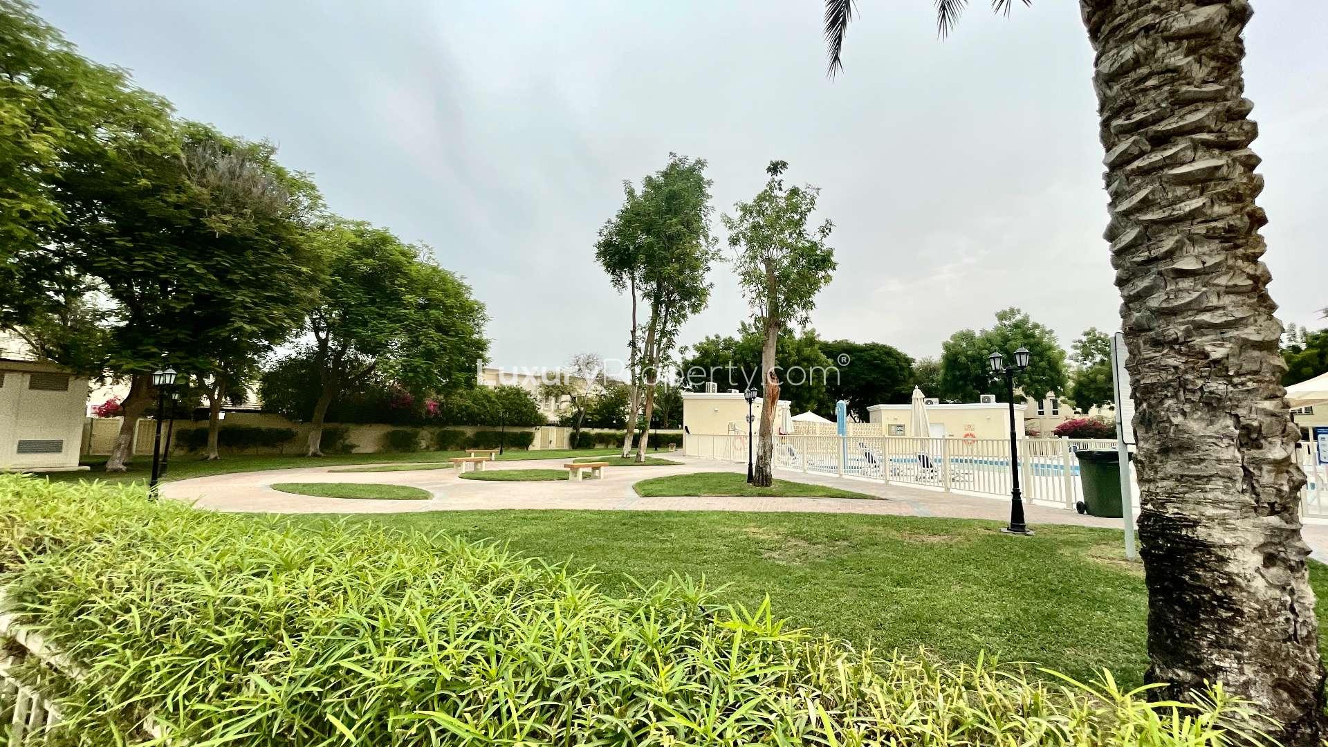 Outdoor community pool area with lush greenery in Springs 14, residential villa for sale