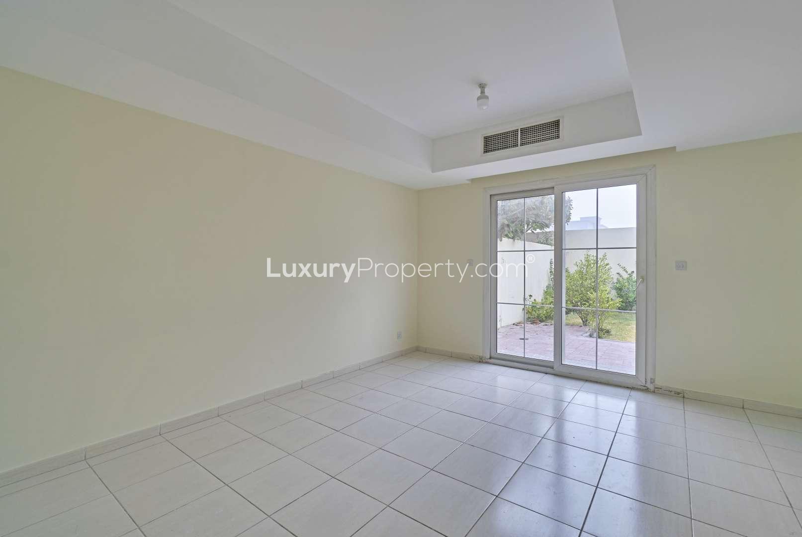 "Front view of vacant 2-bedroom villa for sale in Springs 14, Emirates Living.",Vacant living room in 2-bedroom villa, Springs 14, Emirates Living, with garden view