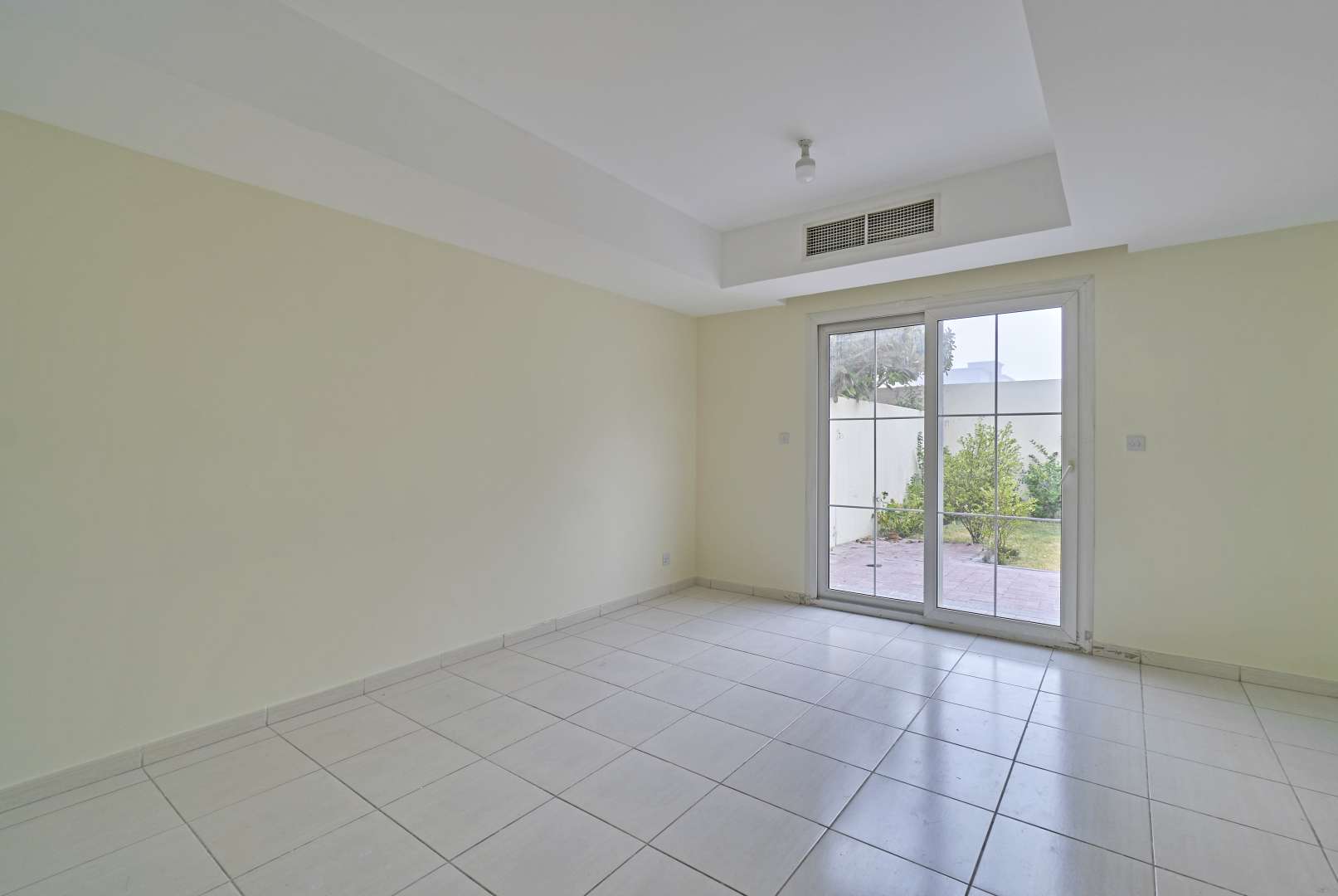 "Front view of vacant 2-bedroom villa for sale in Springs 14, Emirates Living.",Vacant living room in 2-bedroom villa, Springs 14, Emirates Living, with garden view