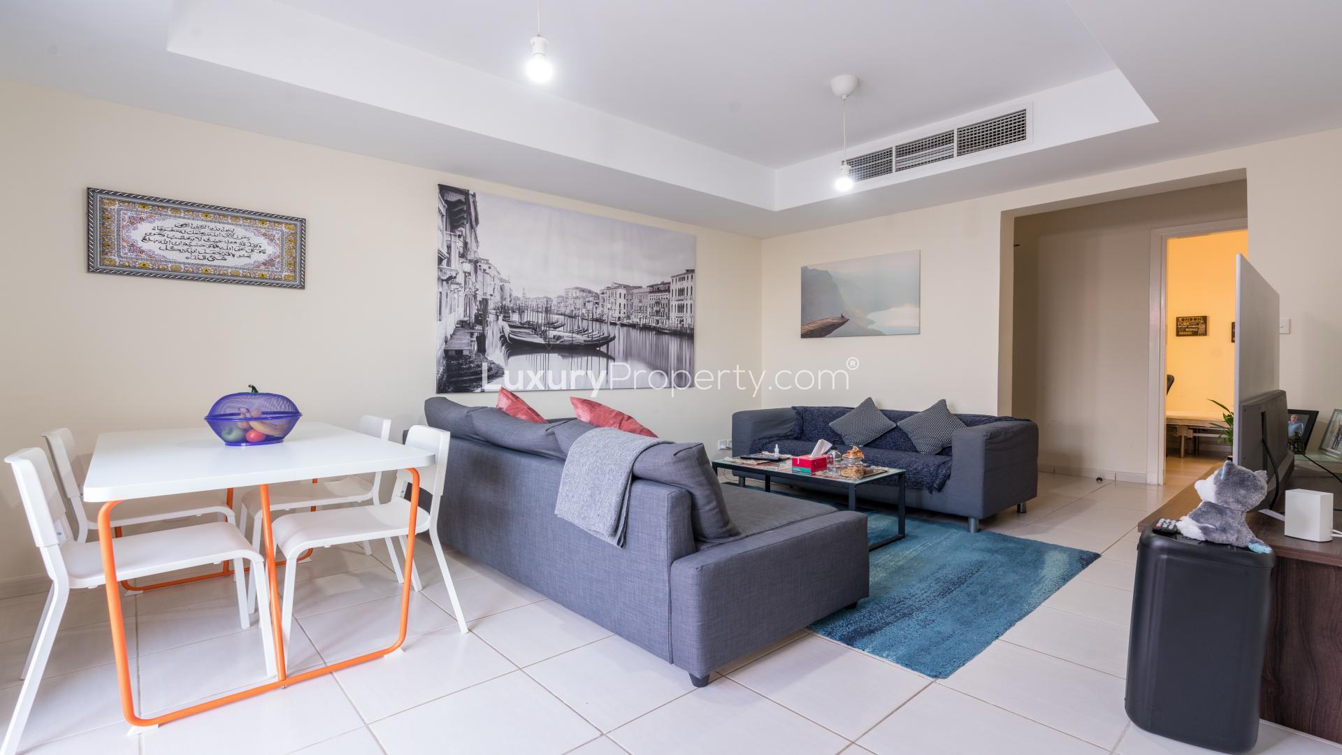 Living room with sectional sofa and garden view in The Springs villa for sale