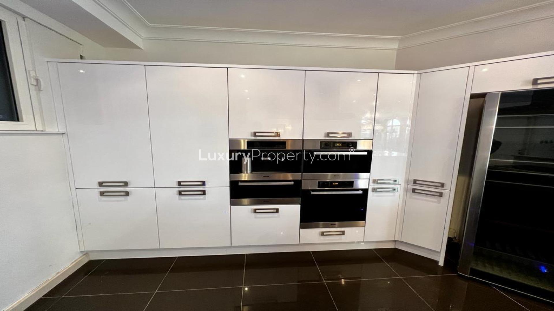 Elegant villa dining room with chandelier, hardwood floors, and large arched windows, LP46815