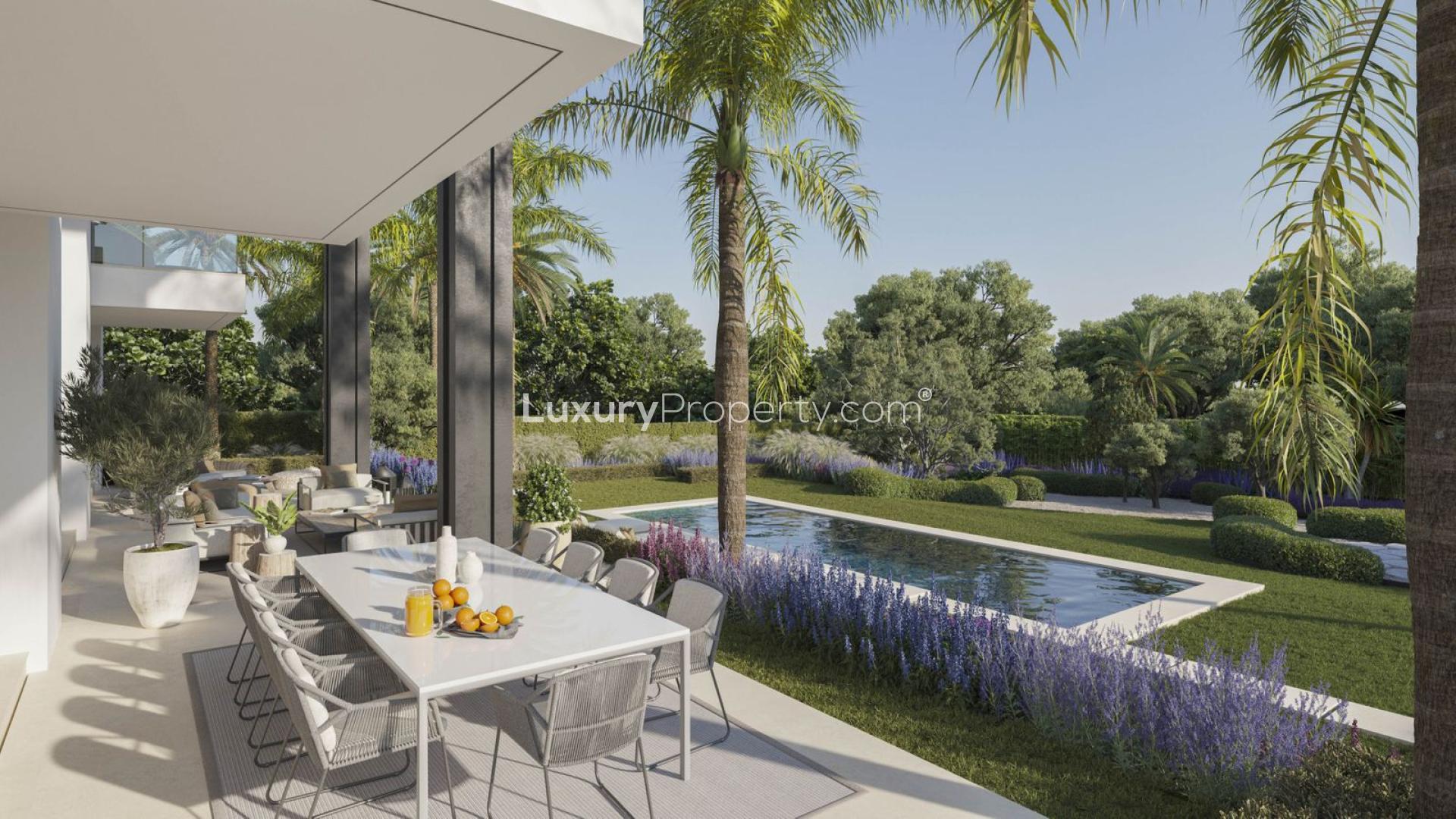 Outdoor dining area overlooking lush garden and pool in Rocio de Nagüeles villa