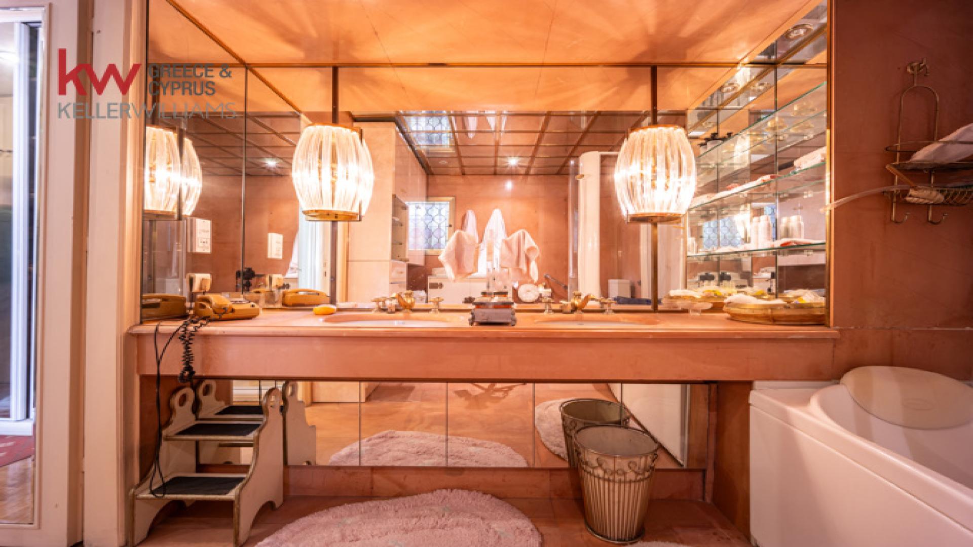 Luxurious Kolonaki apartment bedroom with chandelier, balcony view, and elegant decor