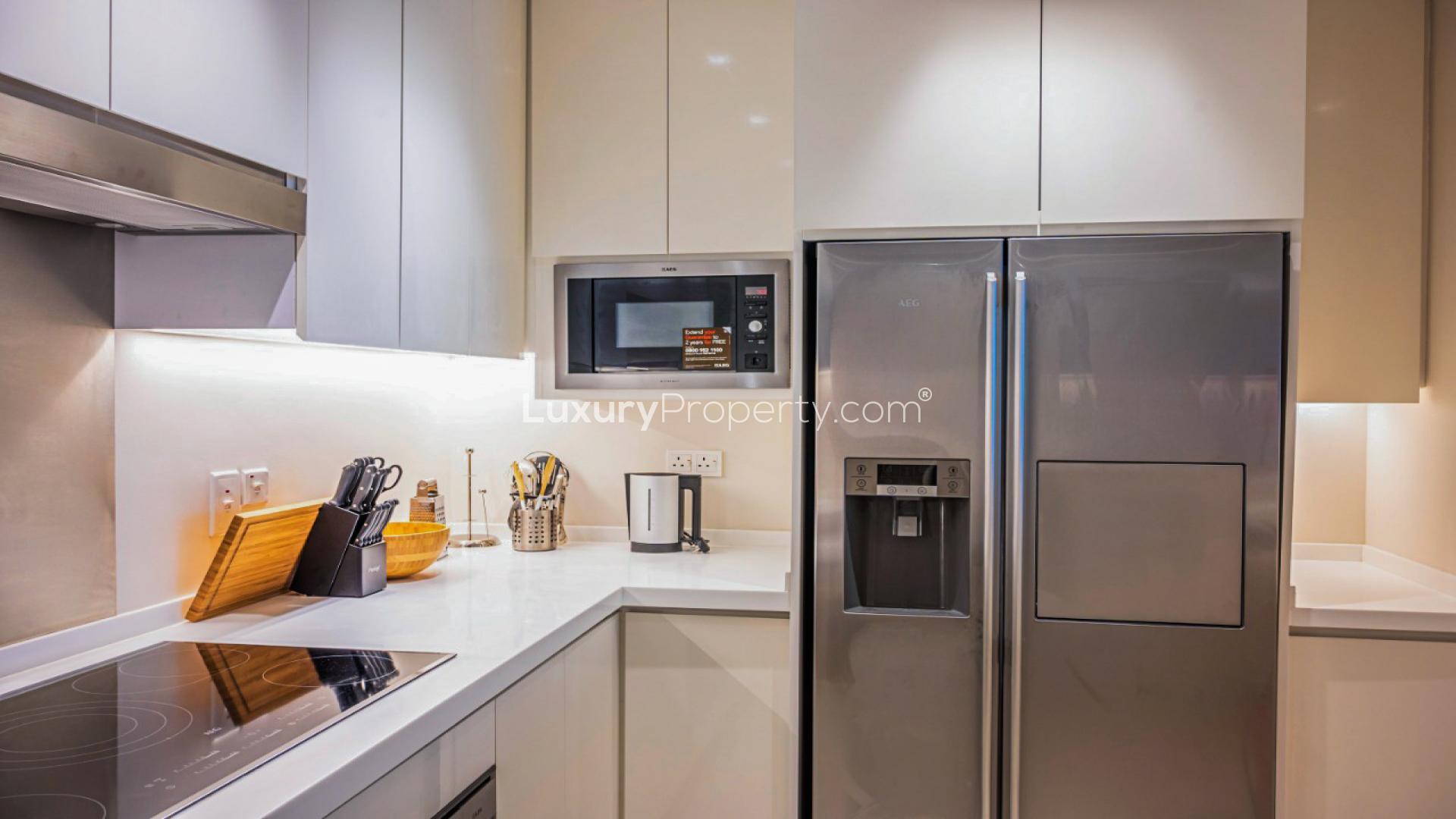 Modern living room with golf views, elegant decor, and large windows in Vida Residence apartment
