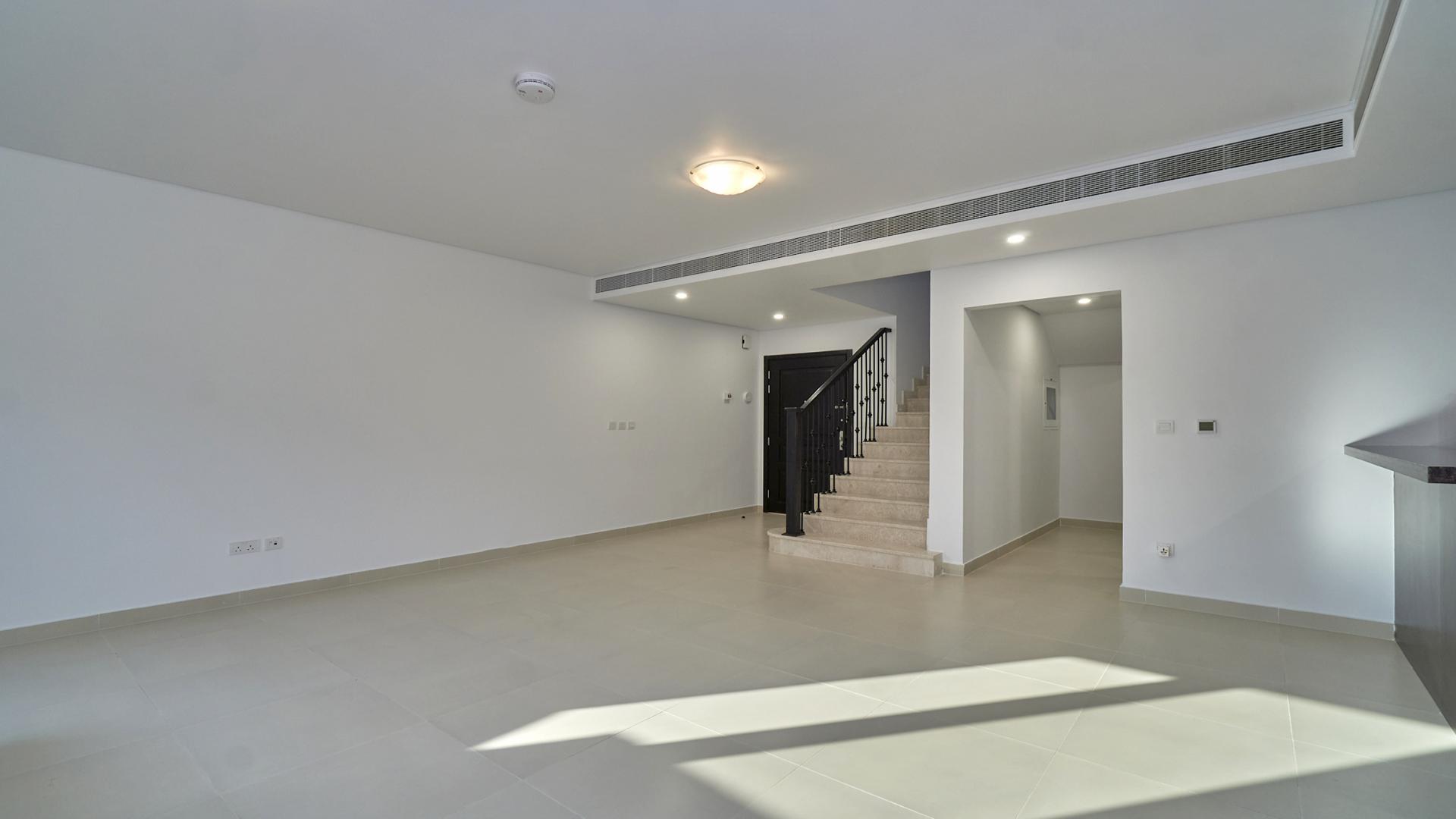 "Spacious townhouse interior with modern kitchen in Serena Bella Casa community, listing LP15237.",Modern living room with staircase in Serena Bella Casa townhouse for sale