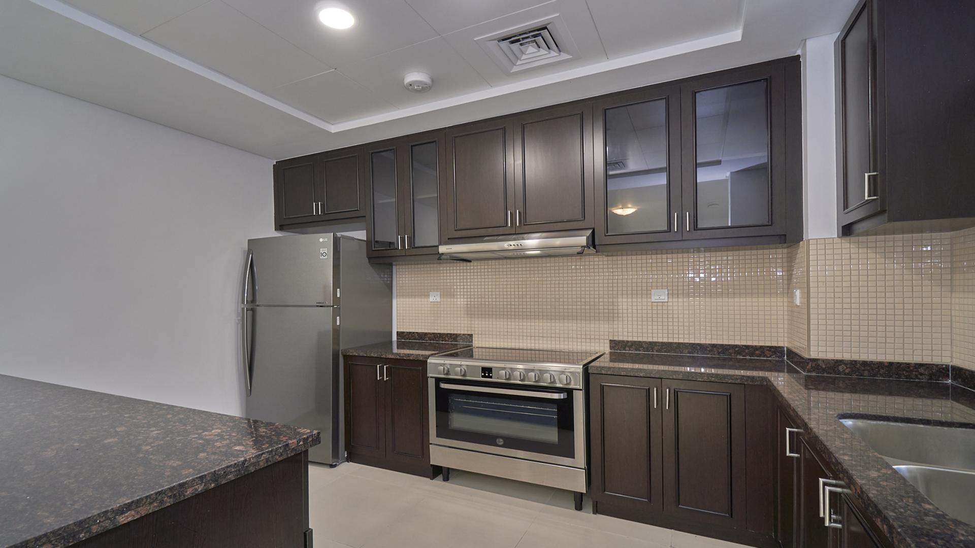 Modern kitchen in Serena Bella Casa townhouse with dark cabinets and stainless steel appliances
