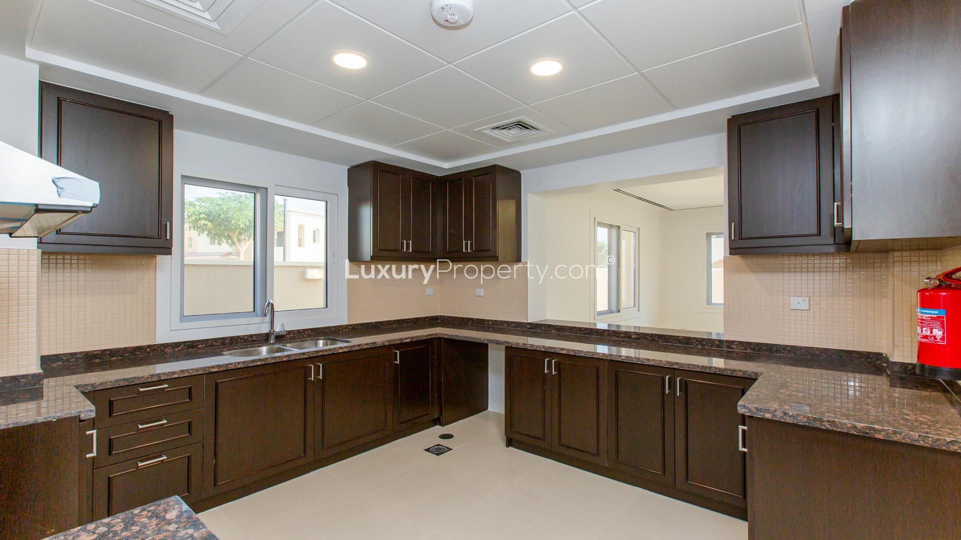 Empty living room with open kitchen in Casa Dora villa, Serena community