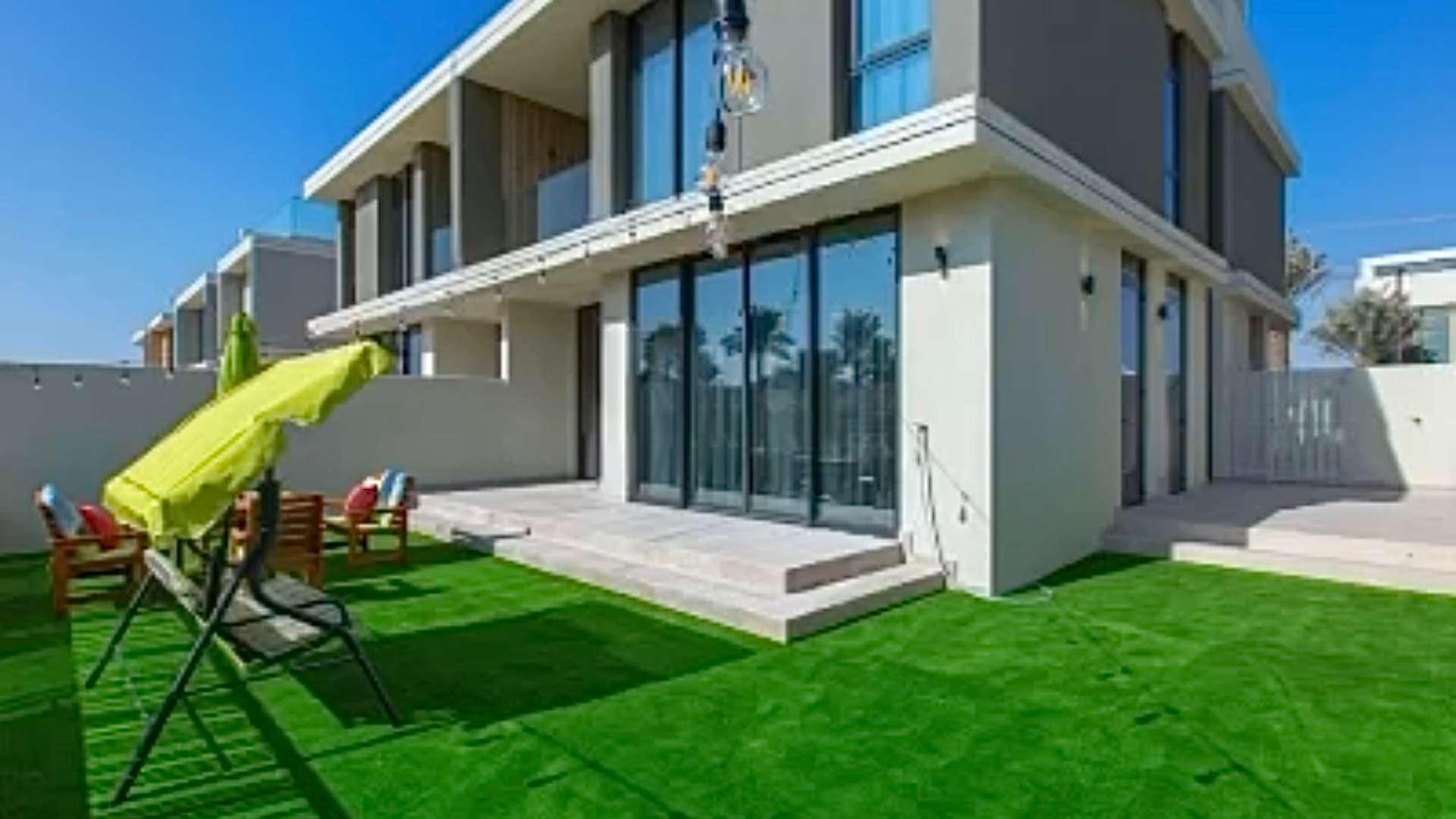 Outdoor patio area in Club Villas at Dubai Hills, featuring seating and greenery