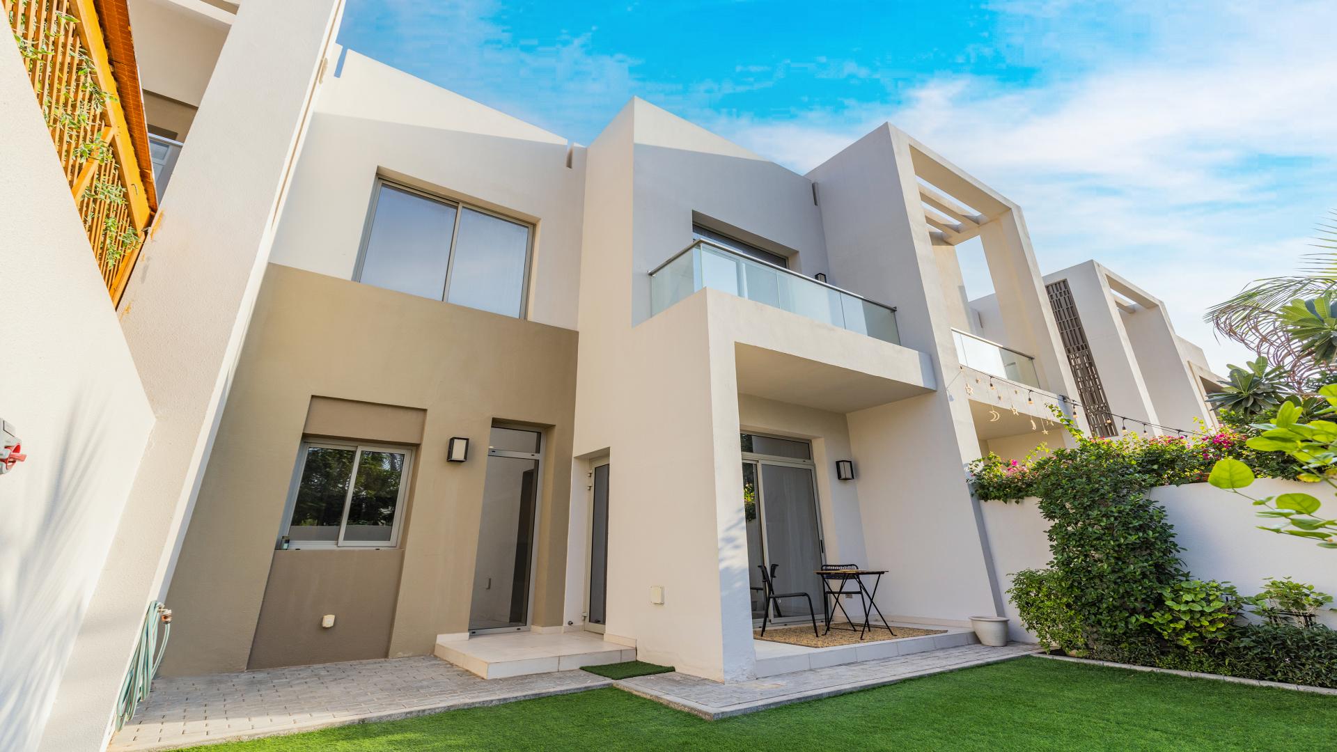 Single-row townhouse exterior in Reem Community, Arabian Ranches 2, with driveway and trees