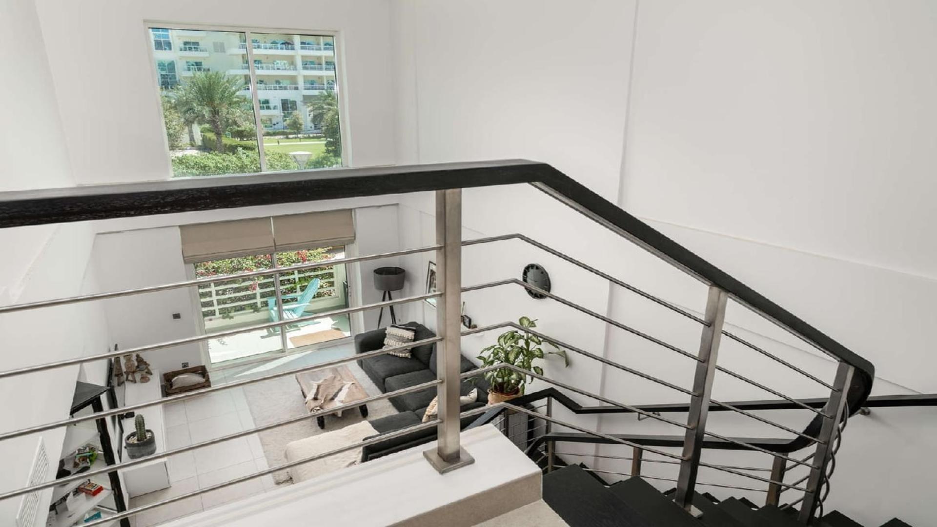 Exterior view of spacious Jumeirah Heights apartment building with playground and lush landscaping