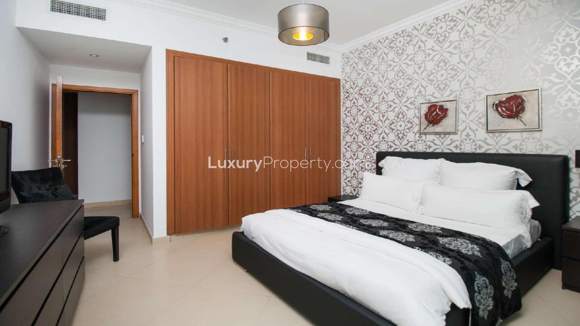 Stylish living room in Dorra Bay apartment, Dubai Marina, with red sofas and patterned walls