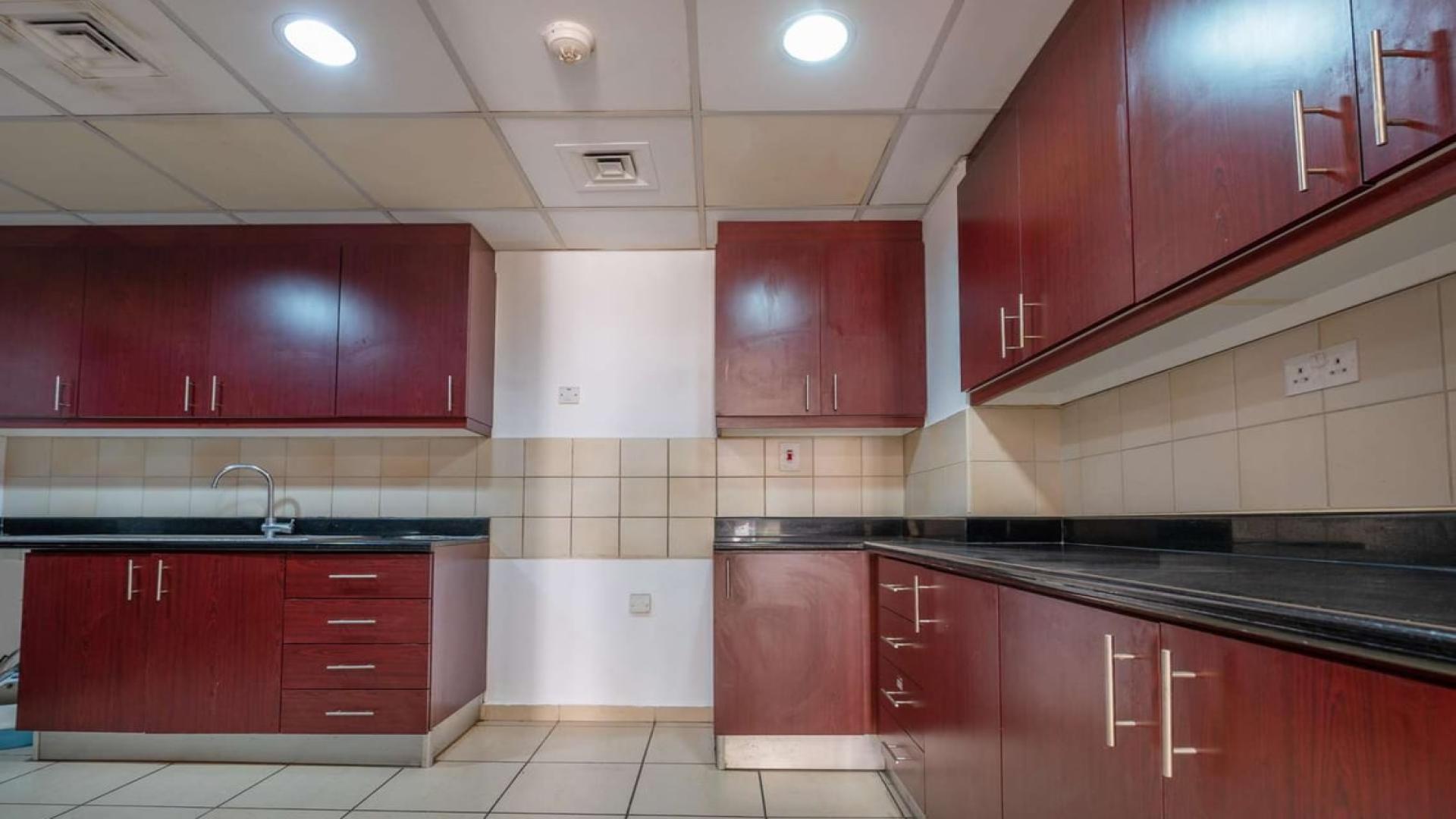 Modern kitchen with wooden cabinets in Jumeirah Beach Residence apartment for sale, Shams community
