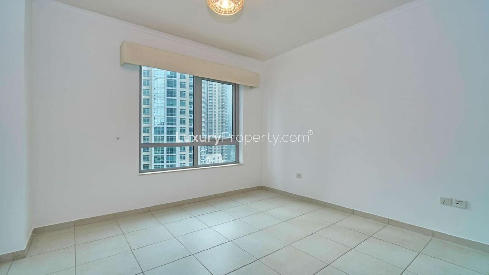 Alt text: "View of Burj Khalifa from luxury apartment in The Residences, Downtown Dubai.",Empty bedroom in Downtown Dubai apartment with large window and cityscape view