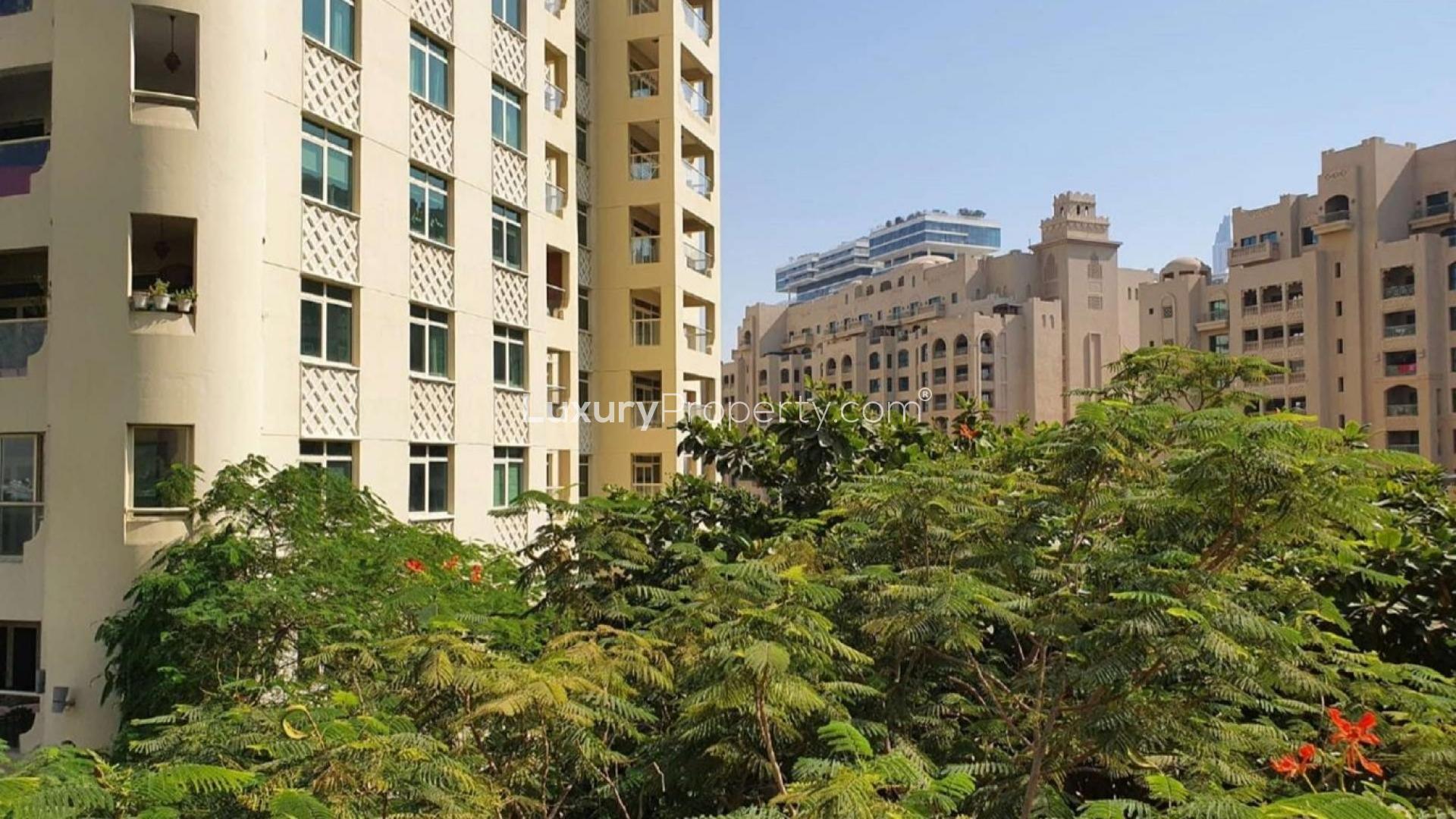Exterior view of Shoreline Apartments with lush greenery, Palm Jumeirah, for rent