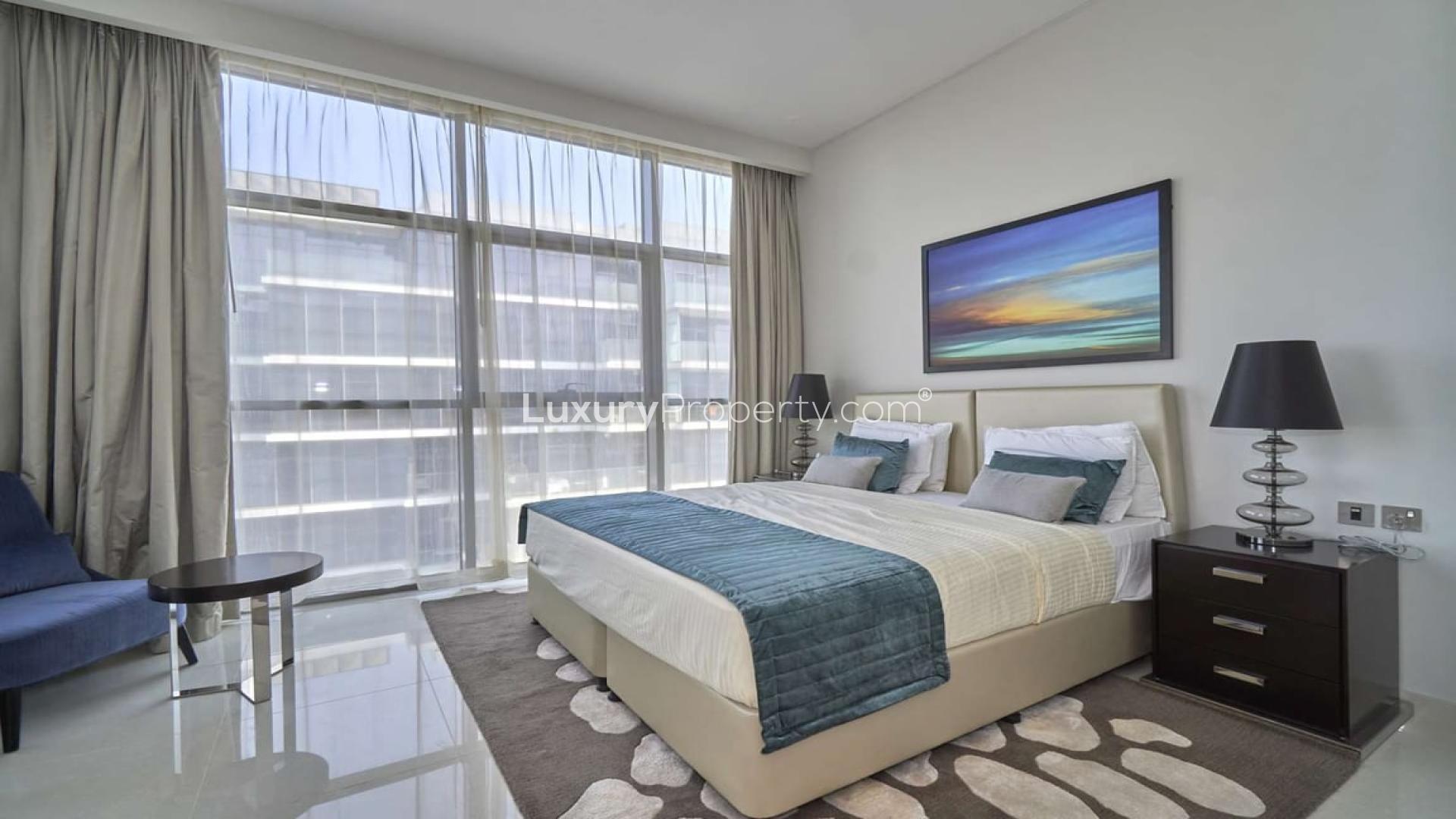 "Spacious balcony view of golf course from Damac Hills apartment for rent, Golf Veduta.",Elegant bedroom in three-bedroom apartment, Golf Veduta, Damac Hills, featuring modern decor and large window